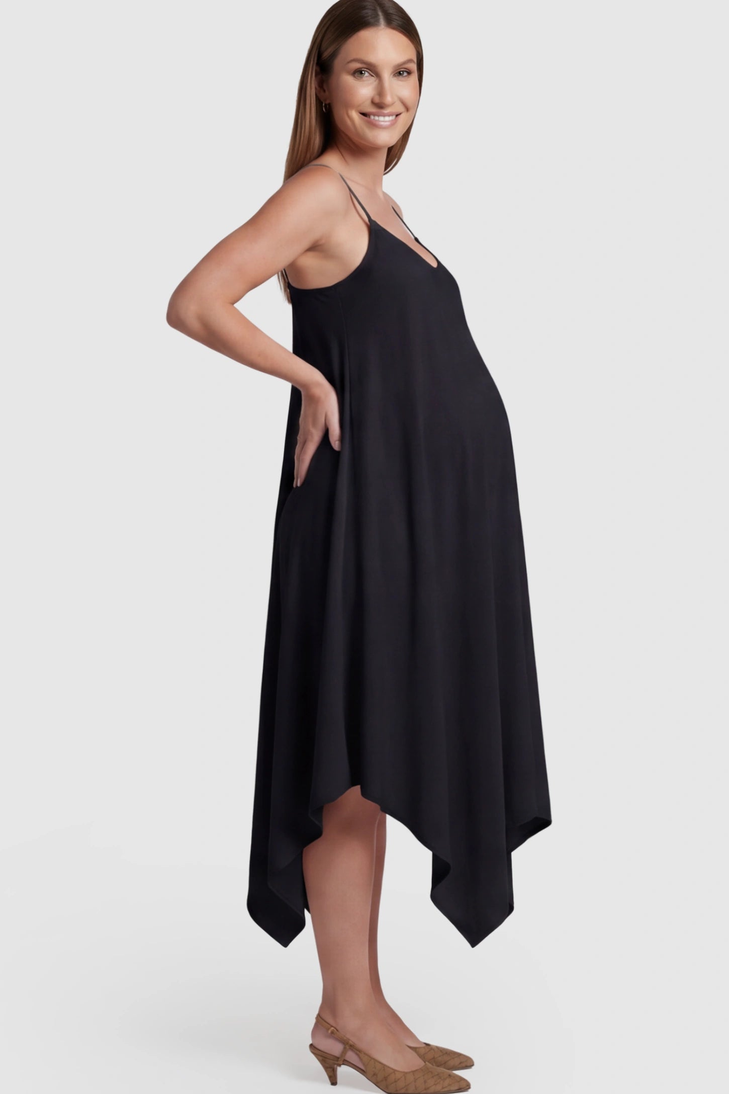 Spaghetti Strap Handkerchief Hem Maternity Midi Dress in Black featuring a scoop-neck on a pregnant model.