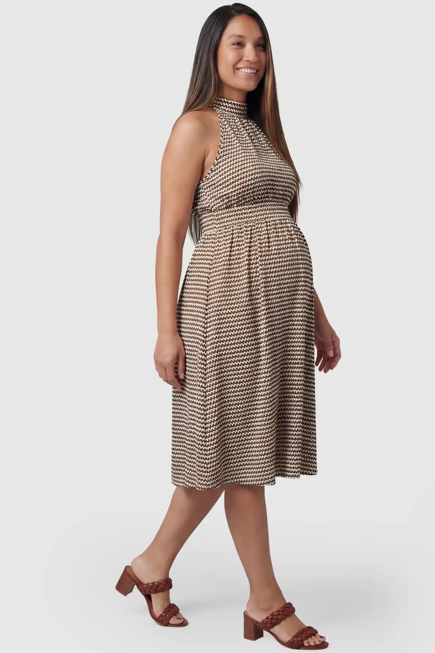 Patterned Print Halter Mock Neck Midi Maternity Dress in Khaki featuring a sleeveless cut on a pregnant model in side view.
