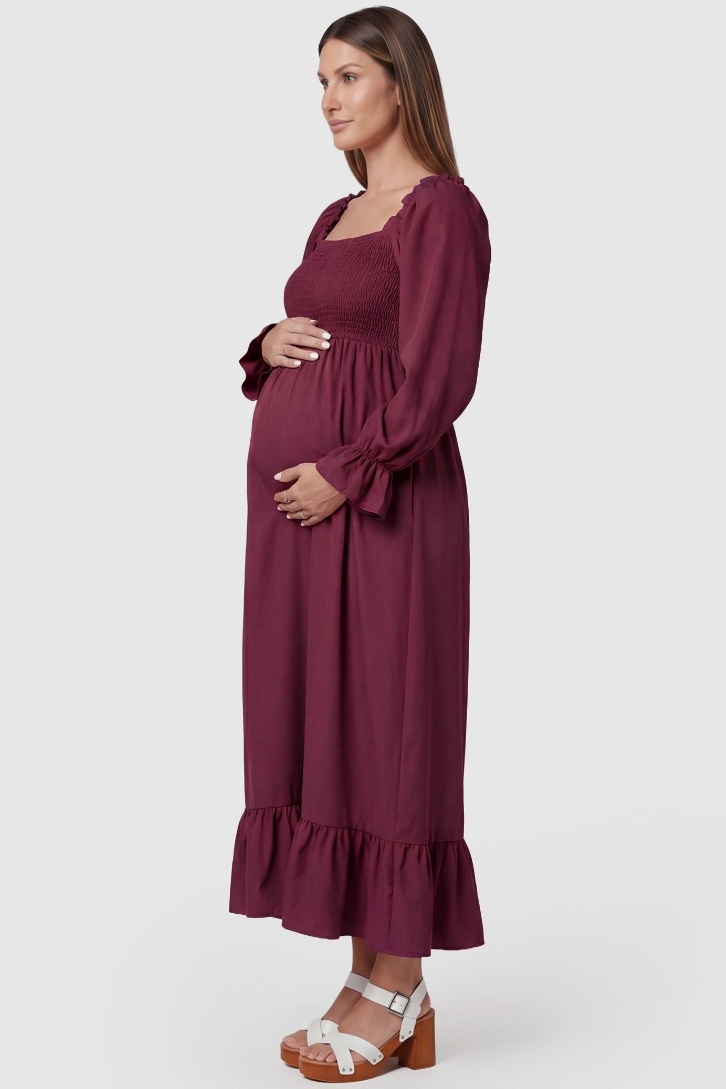Burgundy Square Neck Ruffle Hem Midi Maternity Dress featuring a smocked bodice on a pregnant model in a side profile.