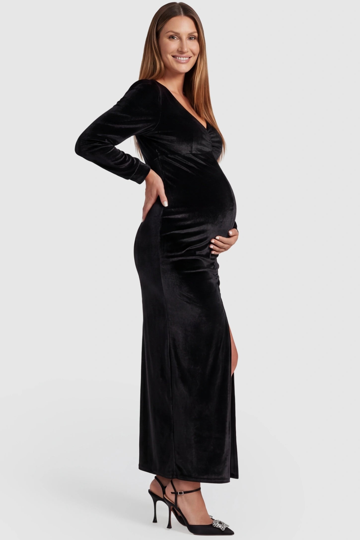 High Slit Velvet Pencil Cut Maternity Evening Dress in Black featuring a thigh-high slit on a pregnant model, side view.
