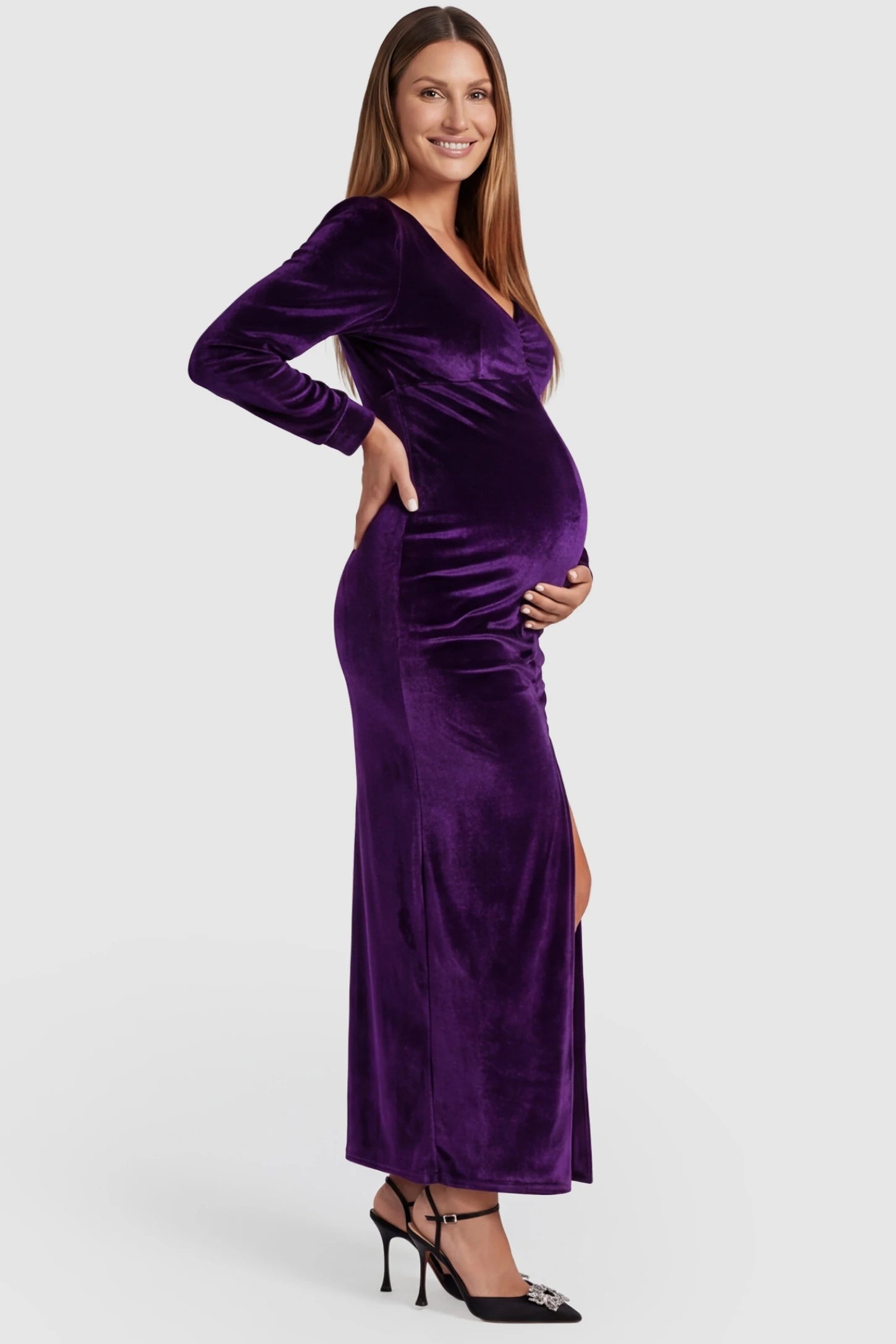 High Slit Velvet Pencil Cut Maternity Evening Dress High Slit Velvet Pencil Cut Maternity Evening Dress in Purple featuring long sleeves on a pregnant model, side view.