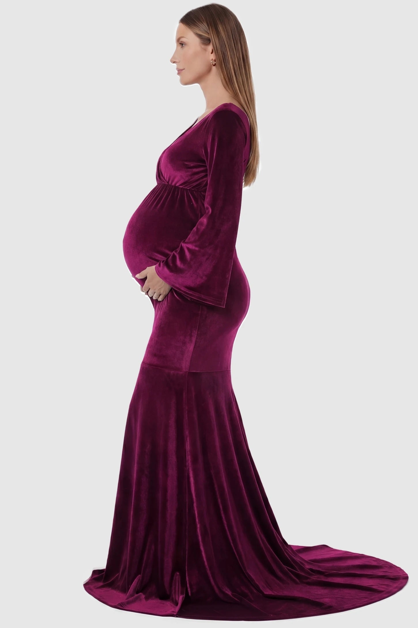 Velvet Long Bell Sleeve Maternity Mermaid Gown Velvet Long Bell Sleeve Maternity Mermaid Gown in Burgundy featuring a side-profile pregnant silhouette and bell sleeves.