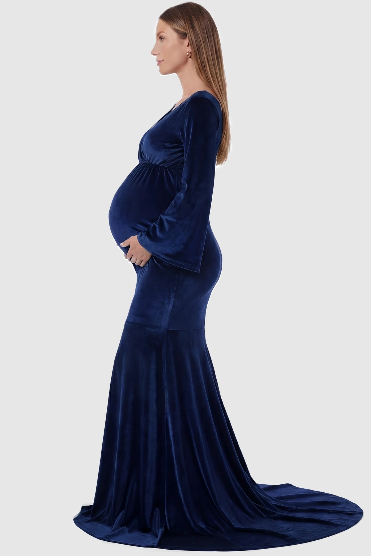 Velvet Long Bell Sleeve Maternity Mermaid Gown Velvet Long Bell Sleeve Maternity Mermaid Gown in Dark Blue featuring a side-profile pregnant silhouette and bell sleeves.