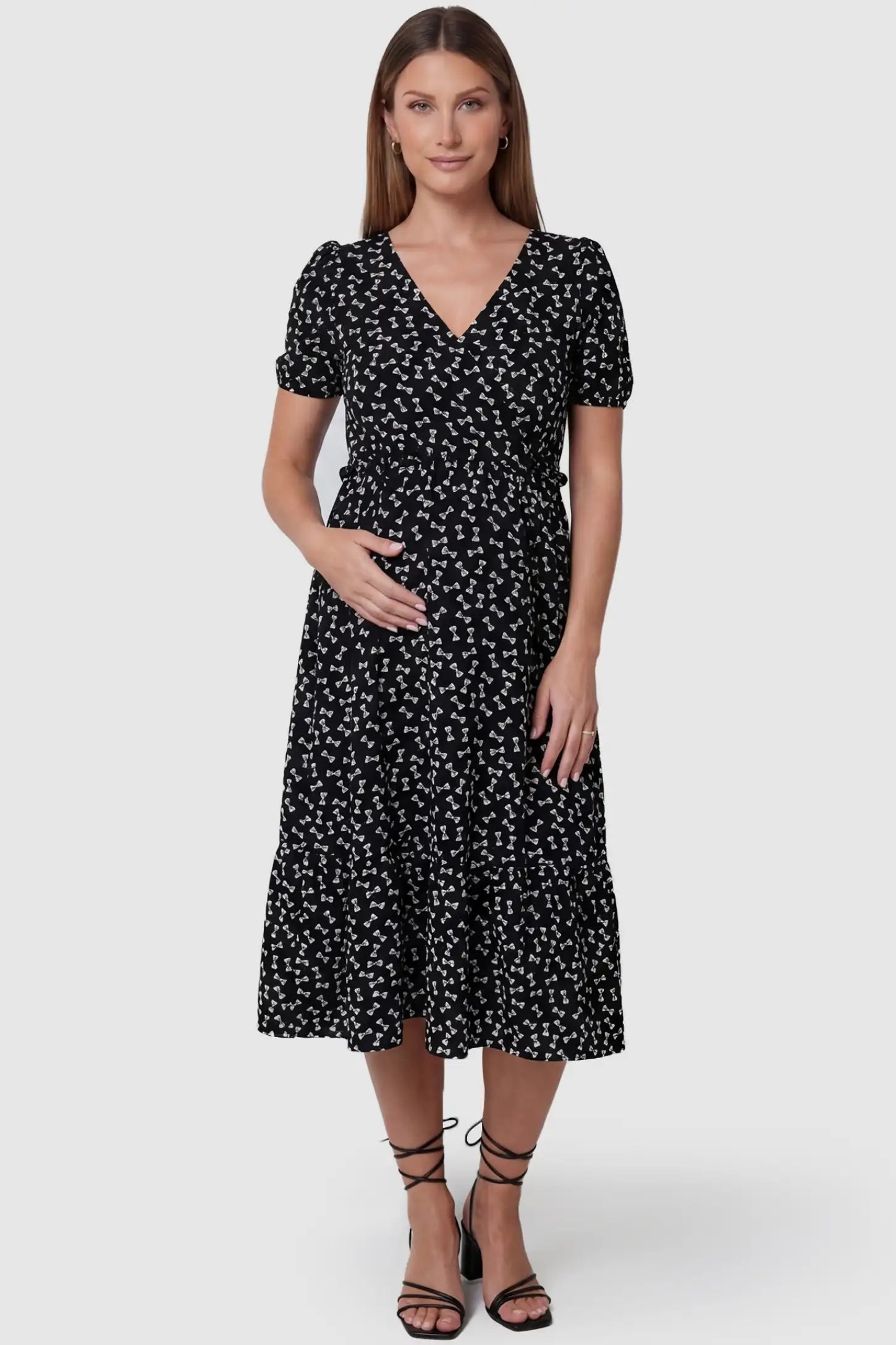 Bow-Print Wrap Midi Maternity Dress in bow-tie pattern featuring puff sleeves on a front-facing pregnant model.