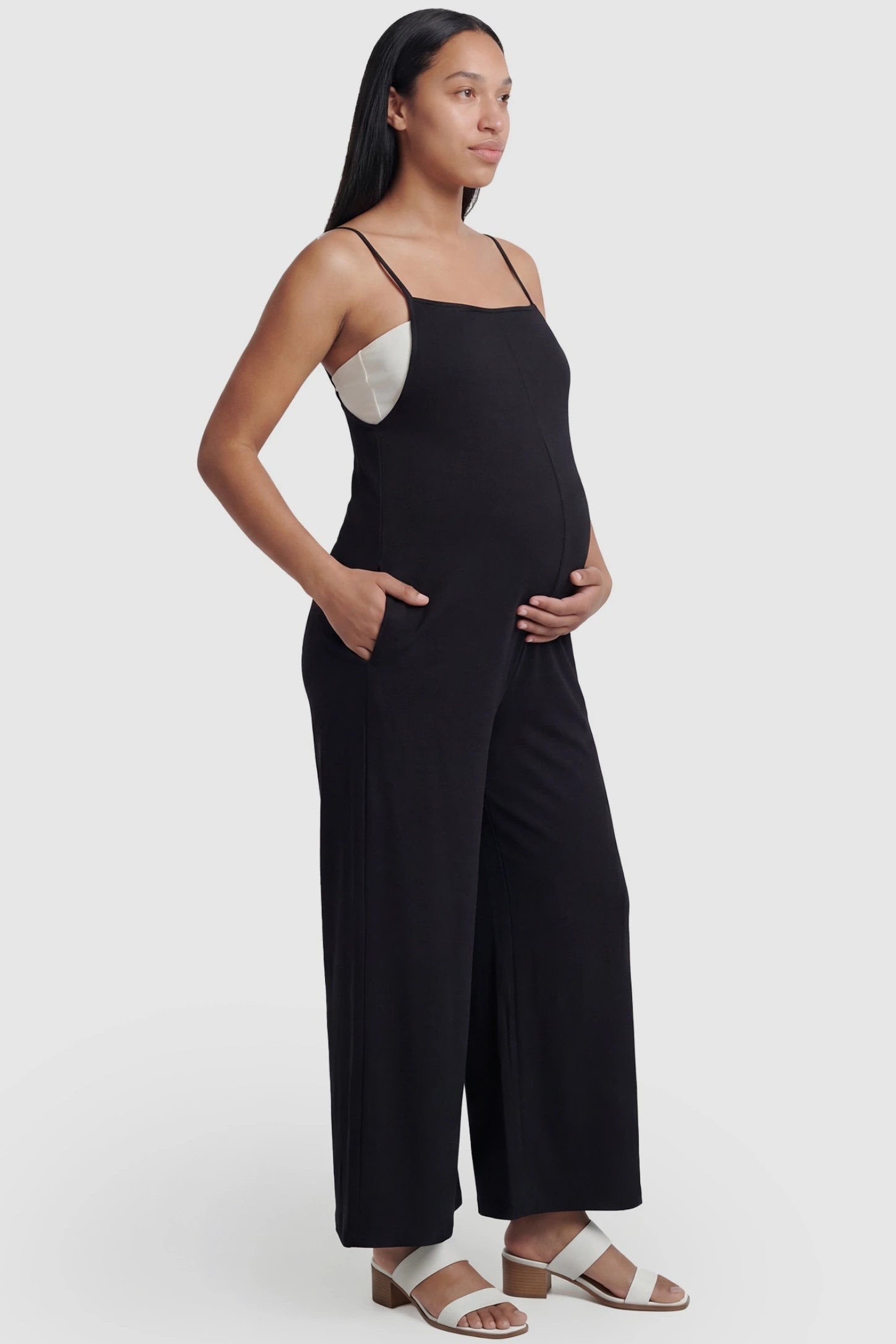 Square-Neck Zippered Wide-Leg Maternity Jumpsuit Square-Neck Zippered Wide-Leg Maternity Jumpsuit in Black featuring a sleek zippered back on a pregnant model.