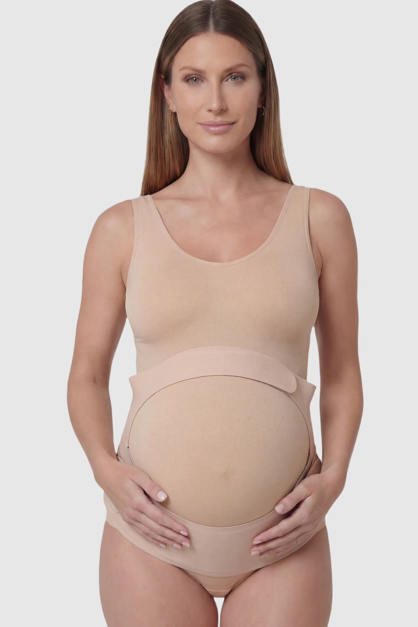 Adjustable Ergonomic Maternity Belly Support Band in Skin featuring an adjustable ergonomic dual-strap design on a pregnant model showing front.