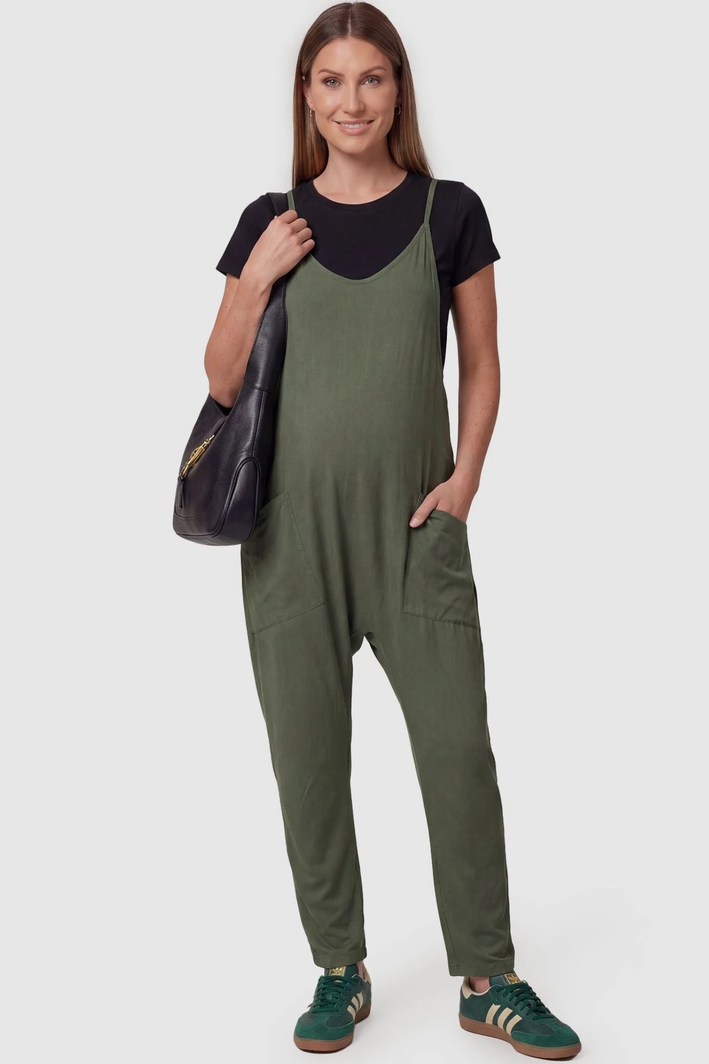 Adjustable Strap Pocketed Relaxed Maternity Jumpsuit Adjustable Strap Pocketed Maternity Jumpsuit in Army Green featuring a relaxed fit on a pregnant model, front view.