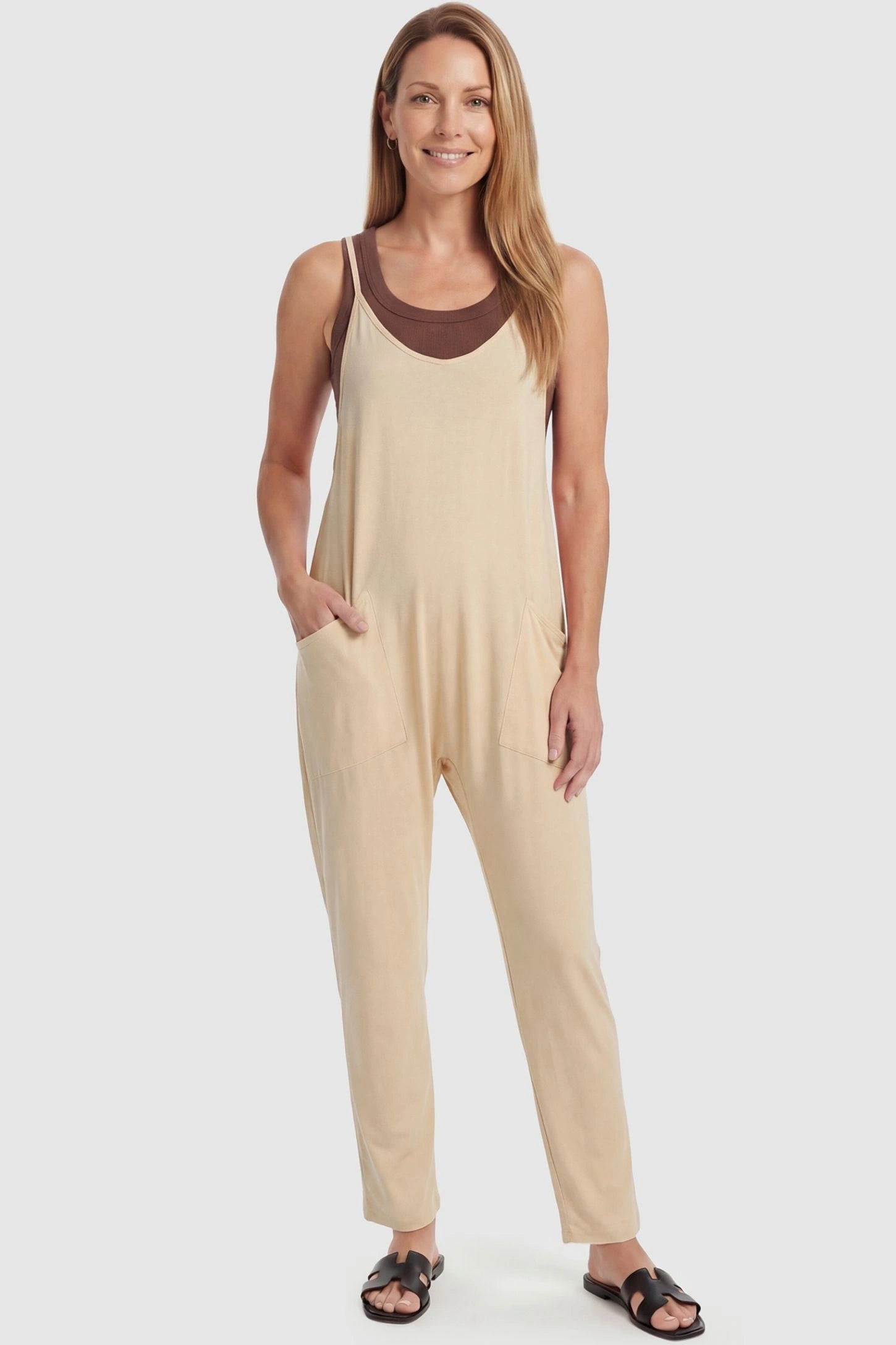 Adjustable Strap Pocketed Relaxed Maternity Jumpsuit Adjustable Strap Pocketed Maternity Jumpsuit in Beige featuring a flexible fit on a non-pregnant model, front view.