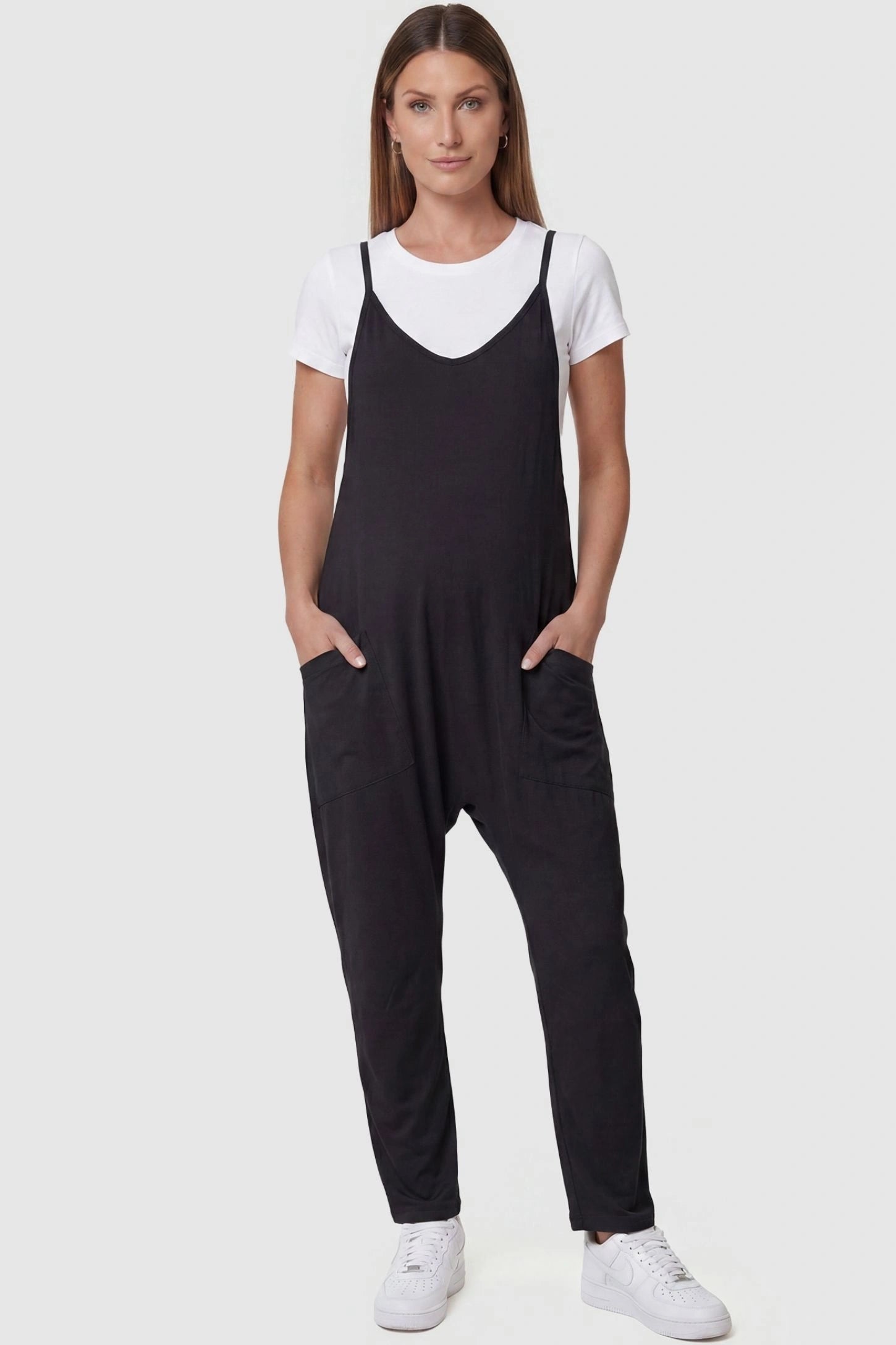 Adjustable Strap Pocketed Relaxed Maternity Jumpsuit Adjustable Strap Pocketed Maternity Jumpsuit in Black featuring a relaxed fit on a pregnant model, front view.