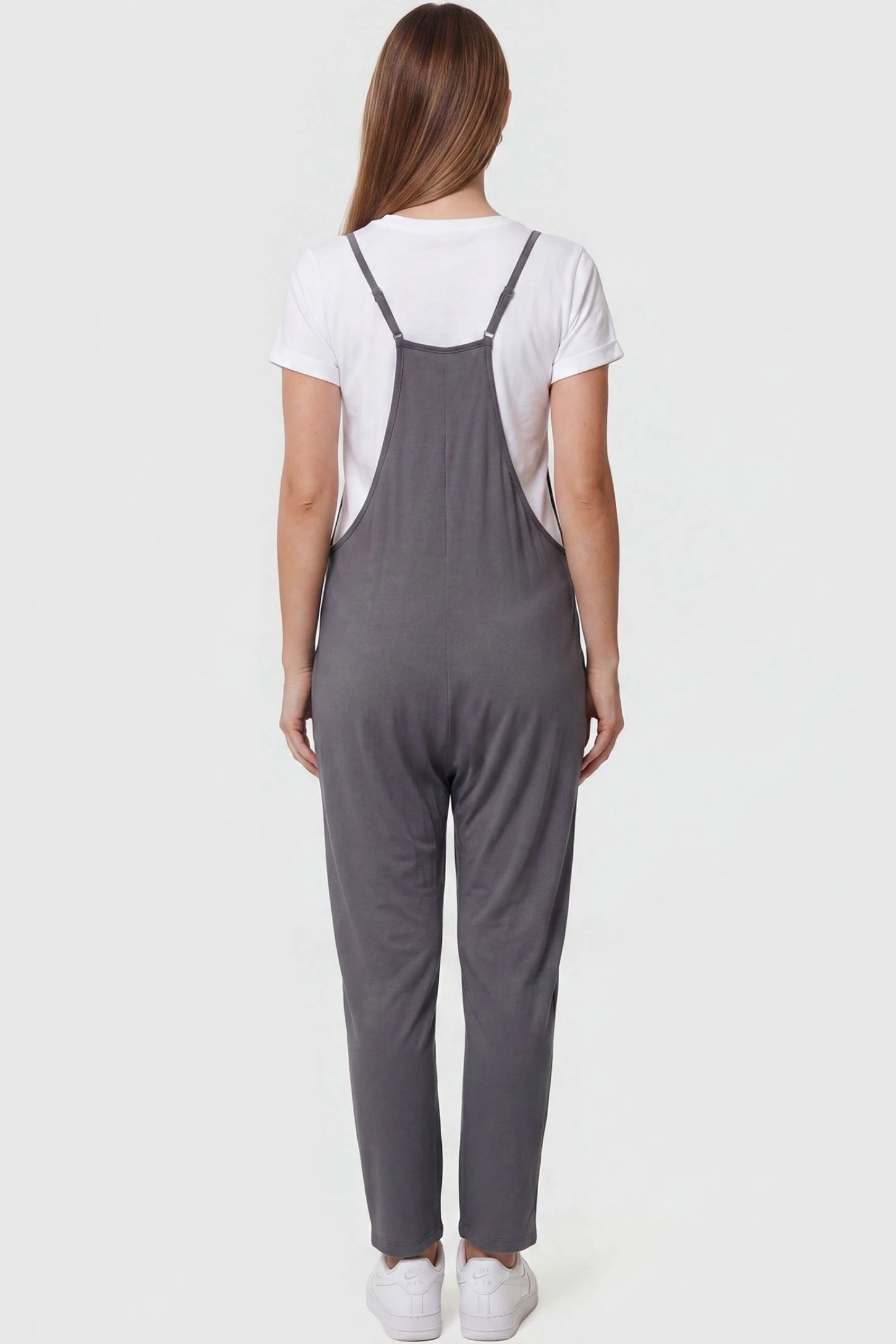 Adjustable Strap Pocketed Relaxed Maternity Jumpsuit Adjustable Strap Pocketed Maternity Jumpsuit in Dark Gray featuring adjustable shoulder straps on a pregnant model, back view.