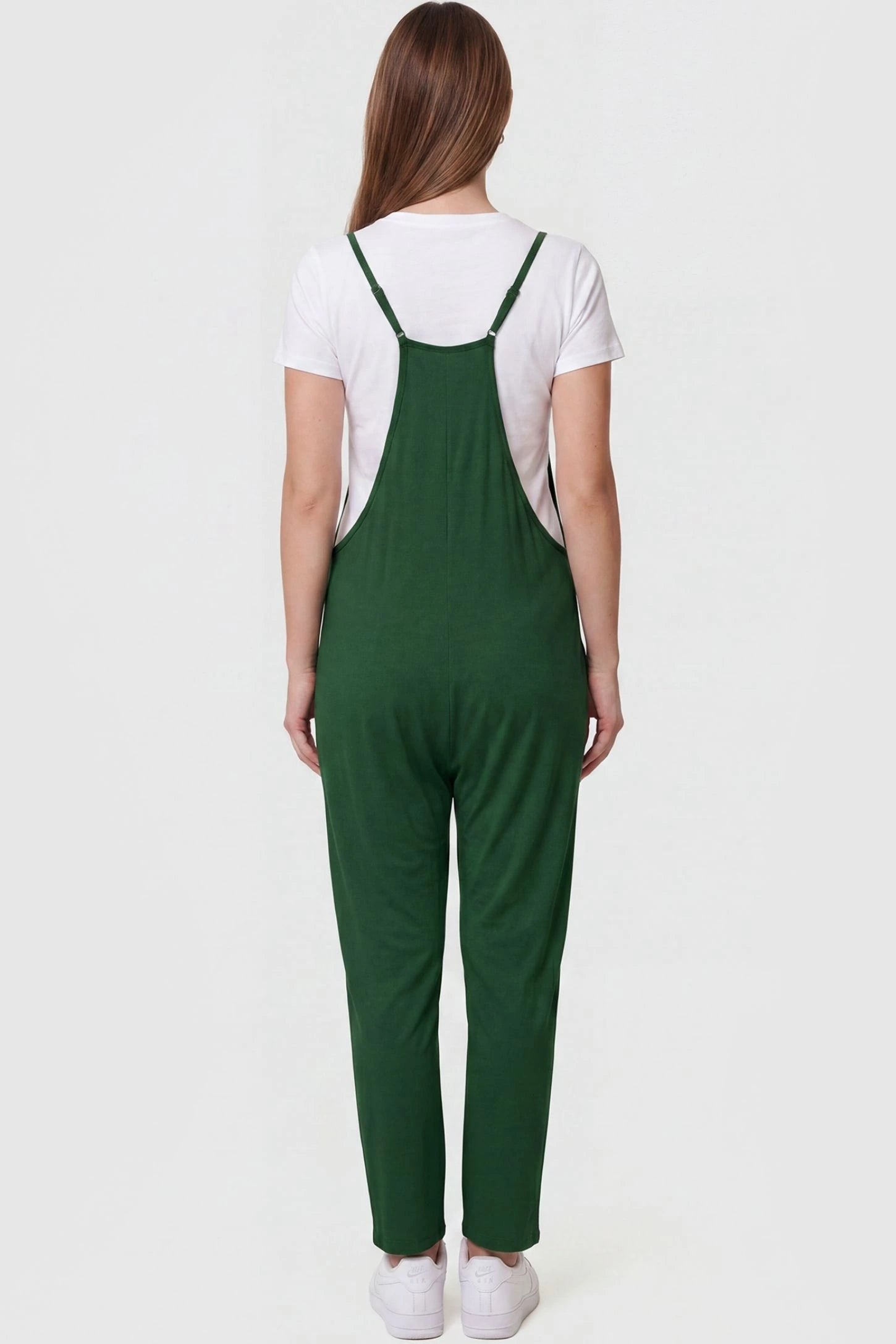 Adjustable Strap Pocketed Relaxed Maternity Jumpsuit Adjustable Strap Pocketed Maternity Jumpsuit in Dark Green featuring adjustable shoulder straps on a pregnant model, back view.