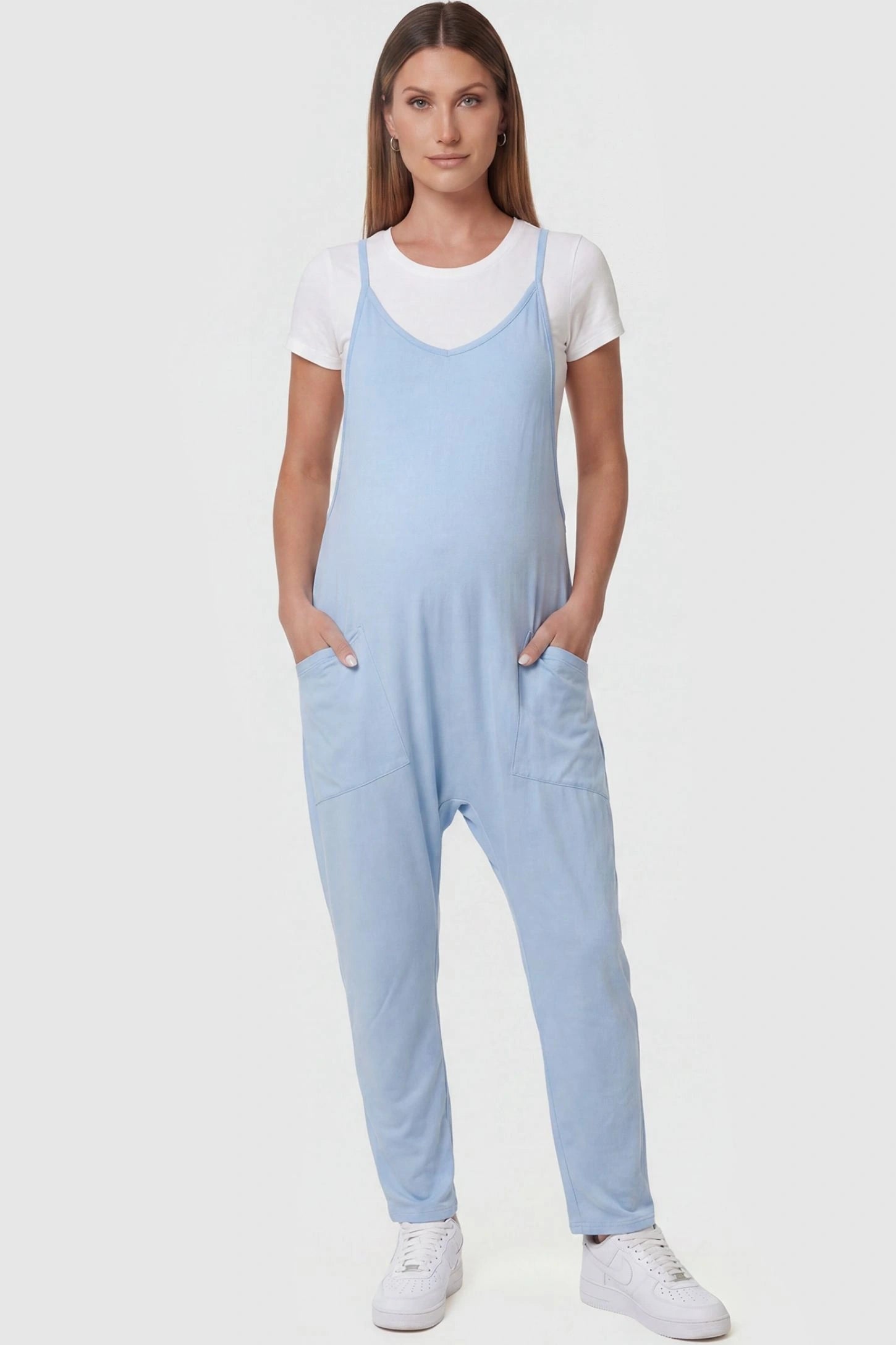 Adjustable Strap Pocketed Relaxed Maternity Jumpsuit Adjustable Strap Pocketed Maternity Jumpsuit in Light Blue featuring a relaxed fit on a pregnant model, front view.
