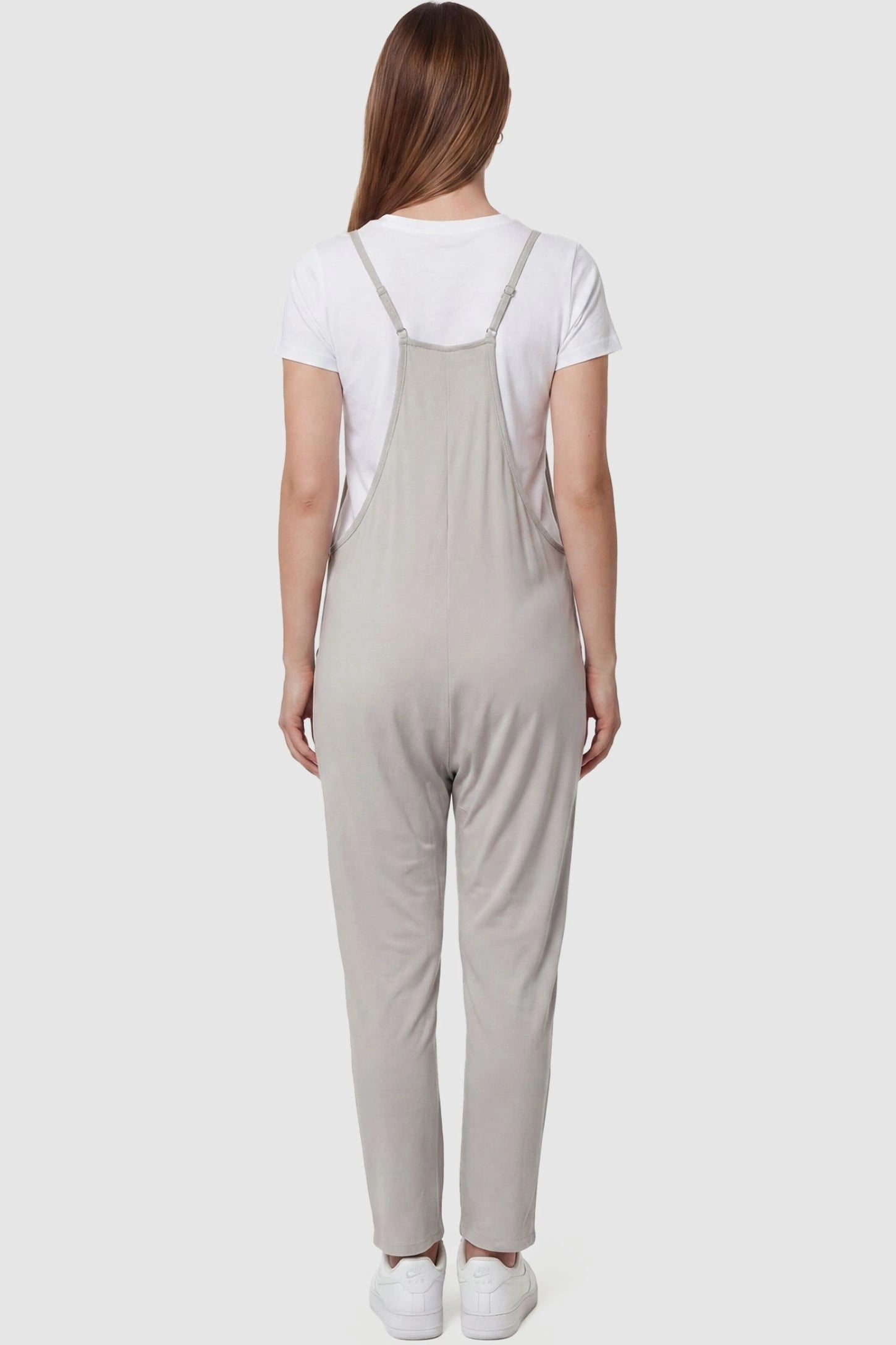Adjustable Strap Pocketed Relaxed Maternity Jumpsuit Adjustable Strap Pocketed Maternity Jumpsuit in Light Gray featuring adjustable shoulder straps on a pregnant model, back view.