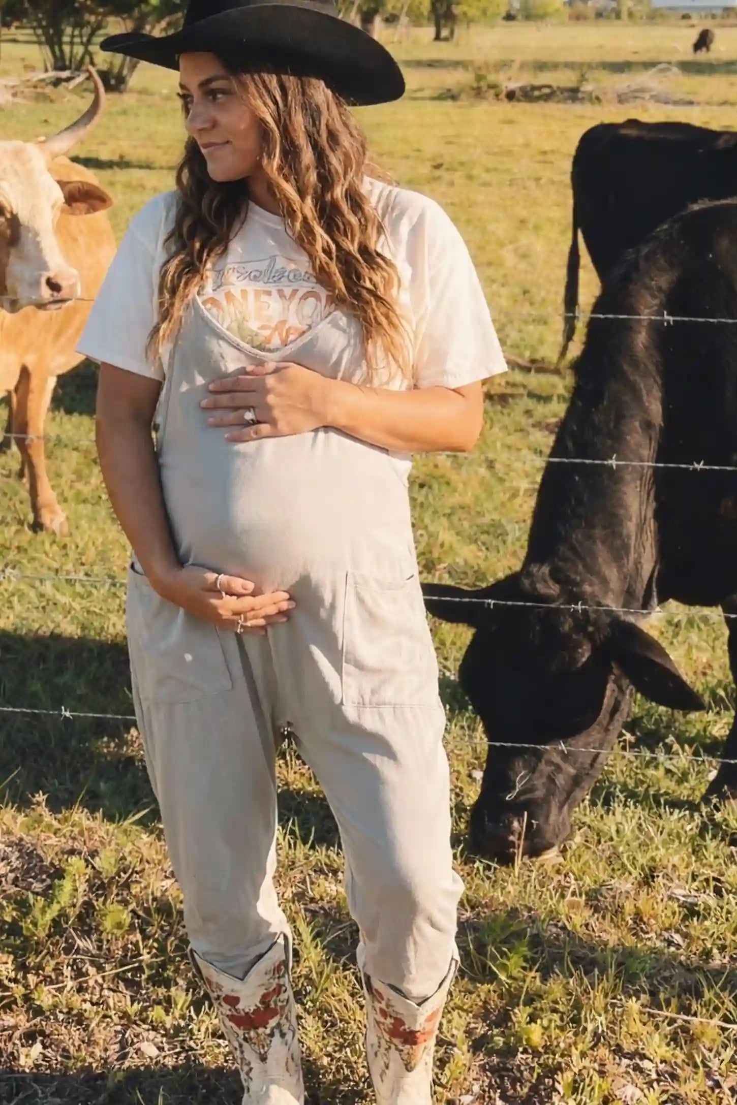 Adjustable Strap Pocketed Relaxed Maternity Jumpsuit Adjustable Strap Pocketed Maternity Jumpsuit in Light Gray showing soft, breathable fabric on a pregnant model, lifestyle view.