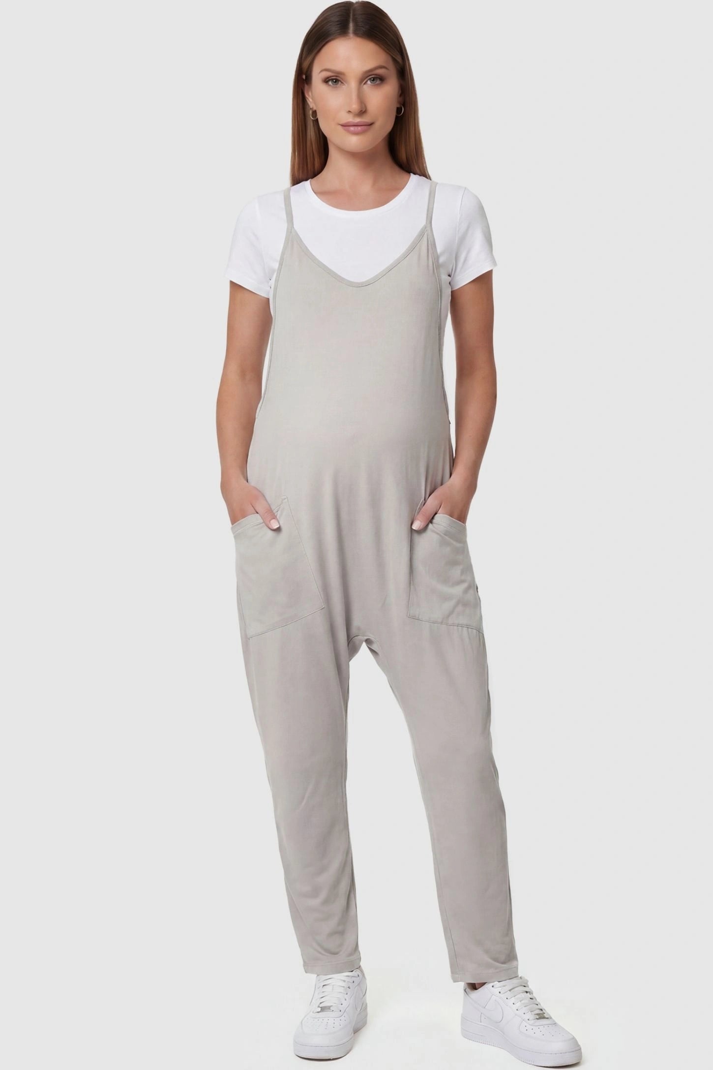 Adjustable Strap Pocketed Relaxed Maternity Jumpsuit Adjustable Strap Pocketed Maternity Jumpsuit in Light Gray featuring a relaxed fit on a pregnant model, front view.
