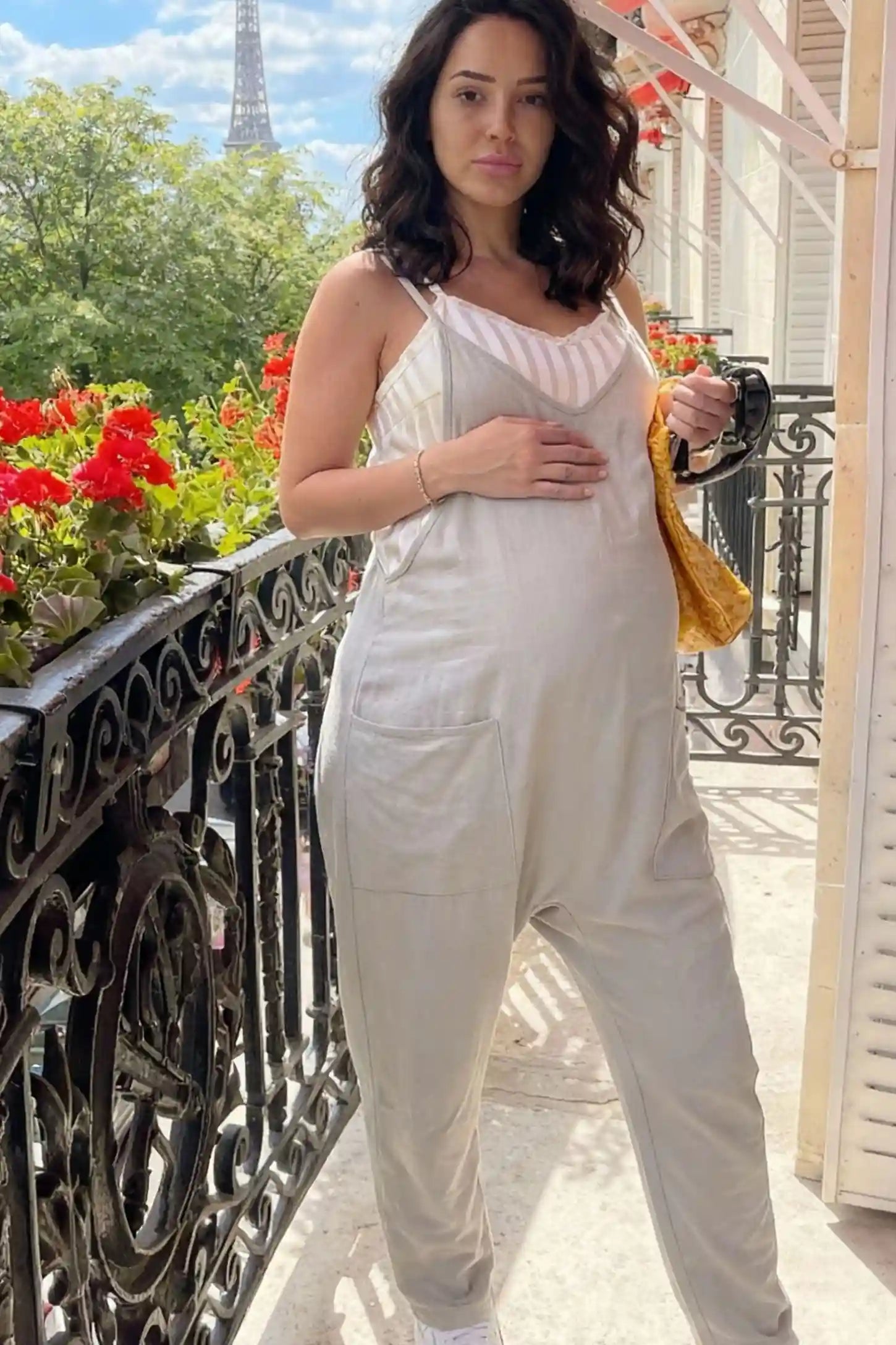 Adjustable Strap Pocketed Relaxed Maternity Jumpsuit Adjustable Strap Pocketed Maternity Jumpsuit in Light Gray showing soft, breathable fabric on a pregnant model, lifestyle view.