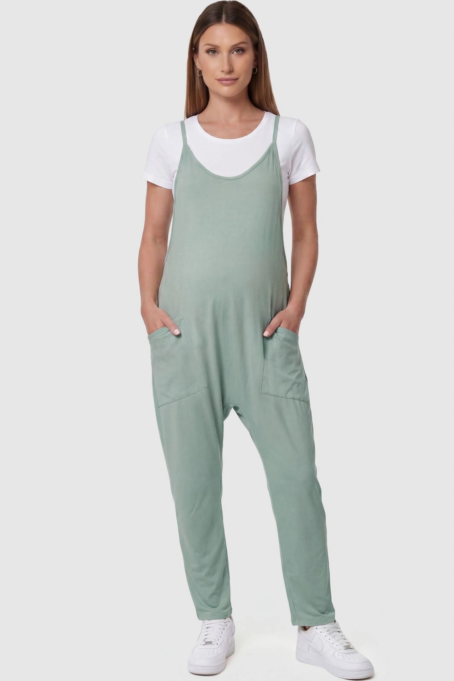 Adjustable Strap Pocketed Relaxed Maternity Jumpsuit Adjustable Strap Pocketed Maternity Jumpsuit in Light Green featuring a relaxed fit on a pregnant model, front view.