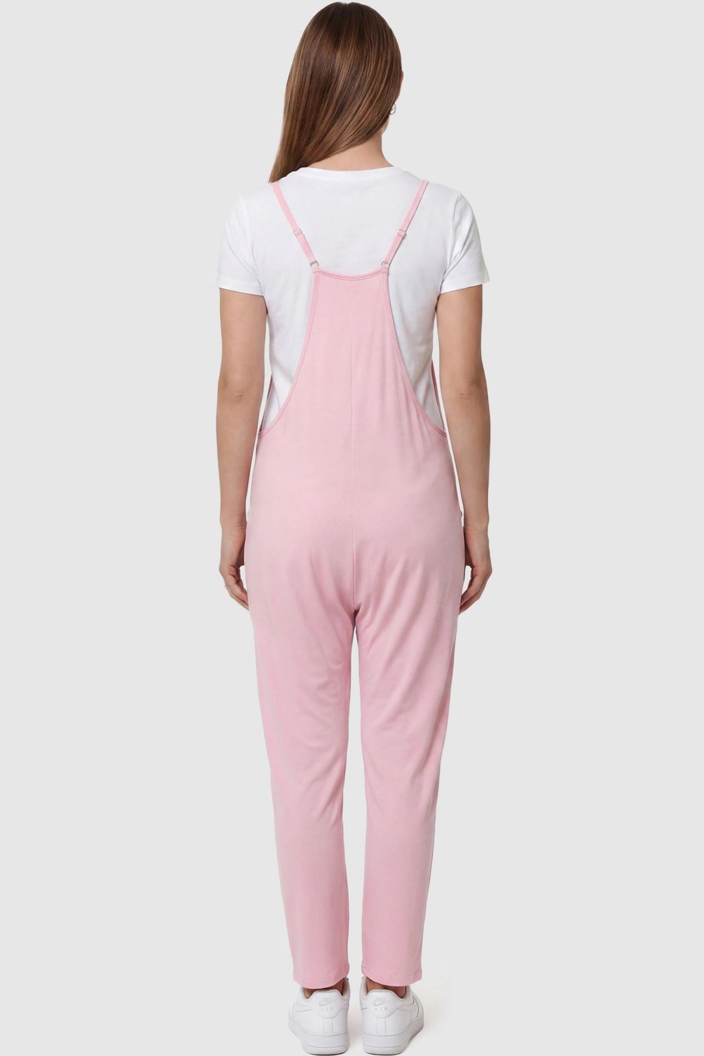 Adjustable Strap Pocketed Relaxed Maternity Jumpsuit Adjustable Strap Pocketed Maternity Jumpsuit in Pink featuring adjustable shoulder straps on a pregnant model, back view.