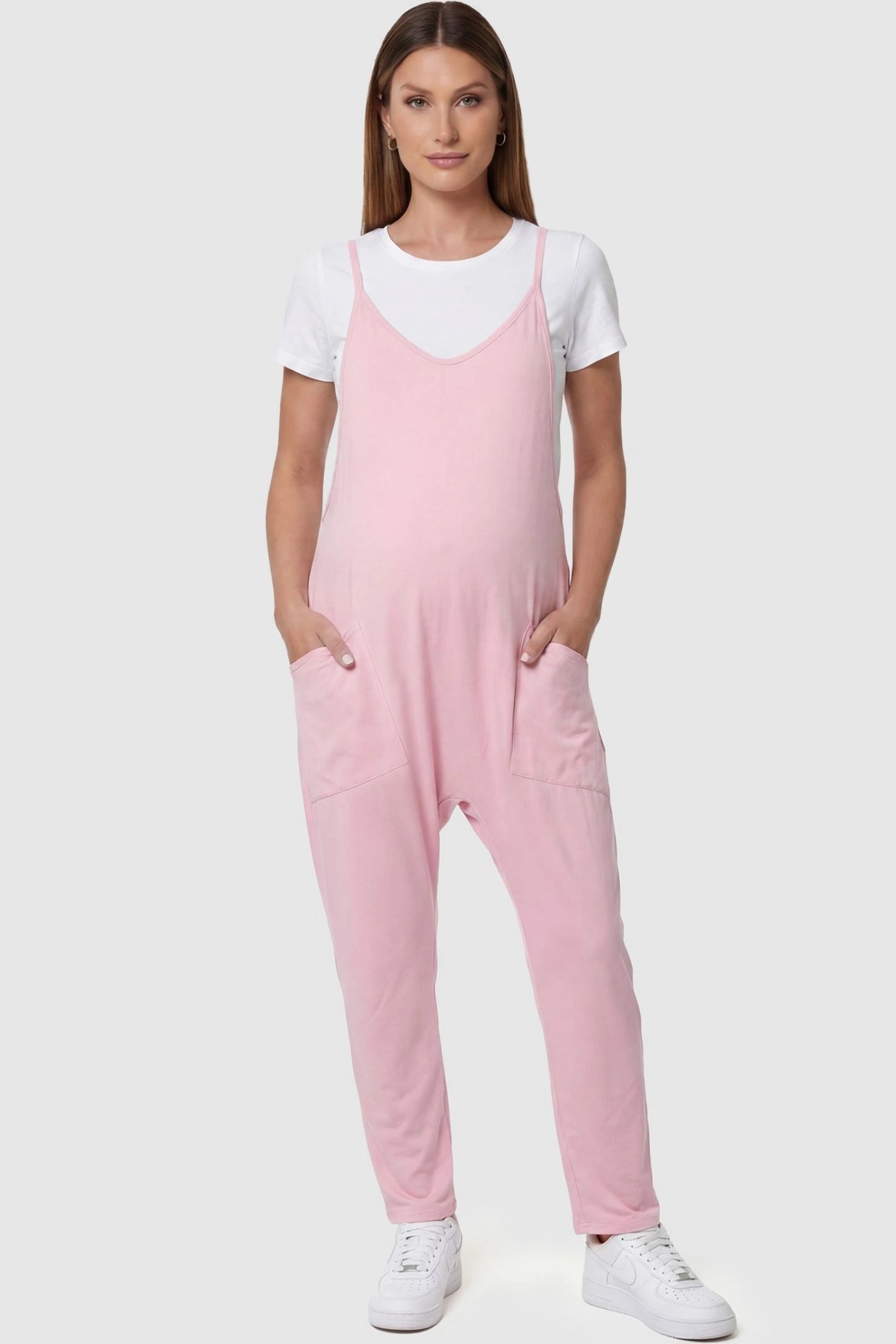 Adjustable Strap Pocketed Relaxed Maternity Jumpsuit Adjustable Strap Pocketed Maternity Jumpsuit in Pink featuring a relaxed fit on a pregnant model, front view.