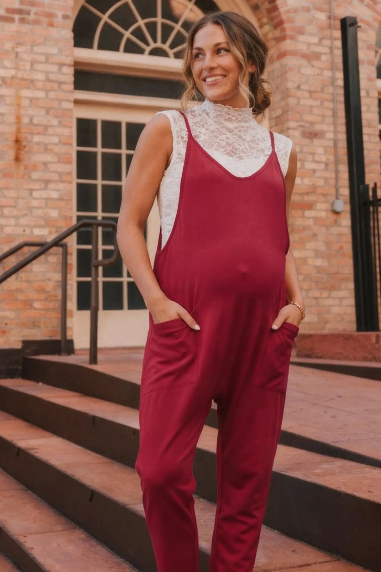 Adjustable Strap Pocketed Relaxed Maternity Jumpsuit Adjustable Strap Pocketed Maternity Jumpsuit in Wine Red showing soft, breathable fabric on a pregnant model, lifestyle view.