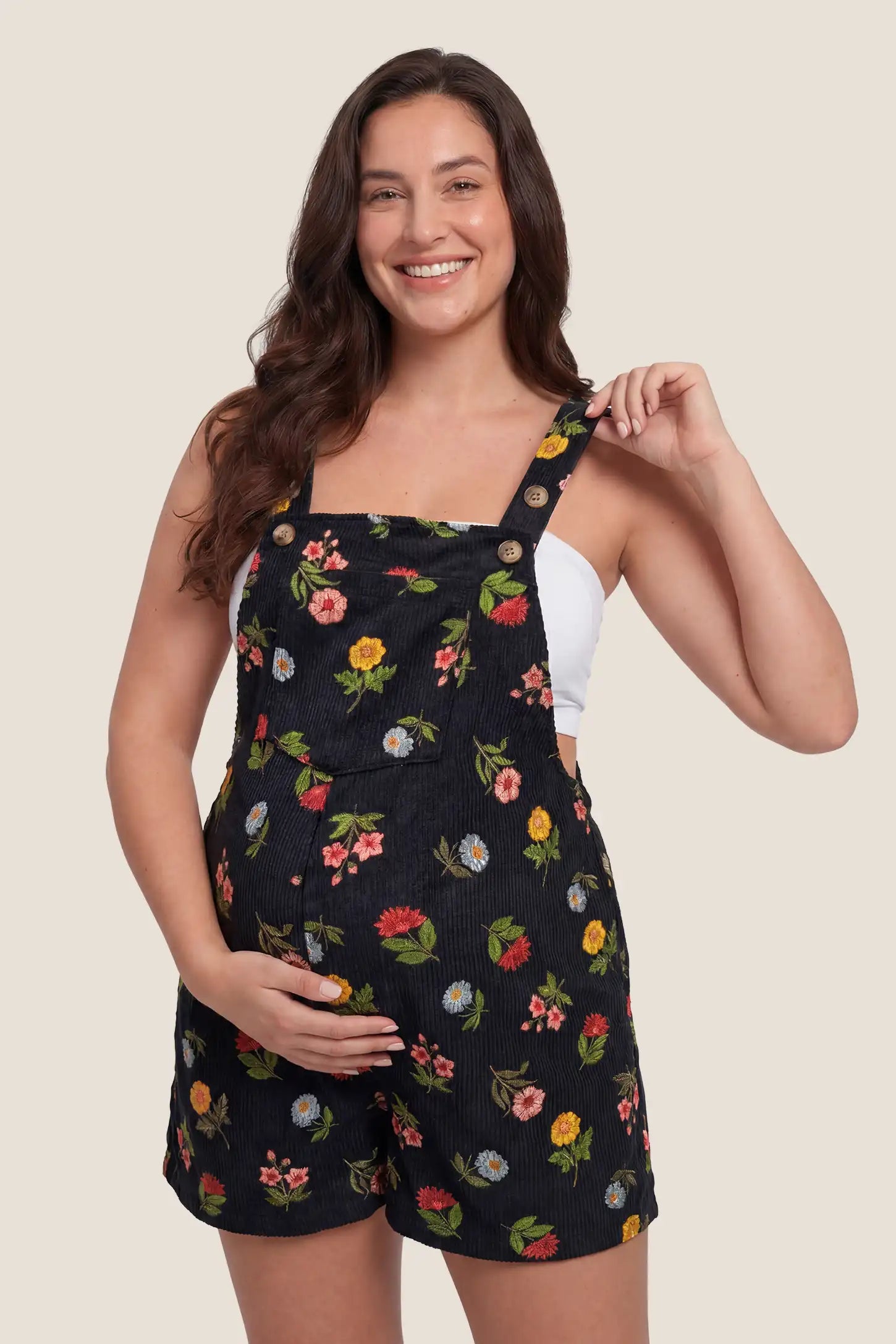 Adjustable Waist Front Pocket Maternity Short Overalls Front view of the black floral Adjustable Waist Front Pocket Maternity Short Overalls with front pockets and adjustable waist detail.
