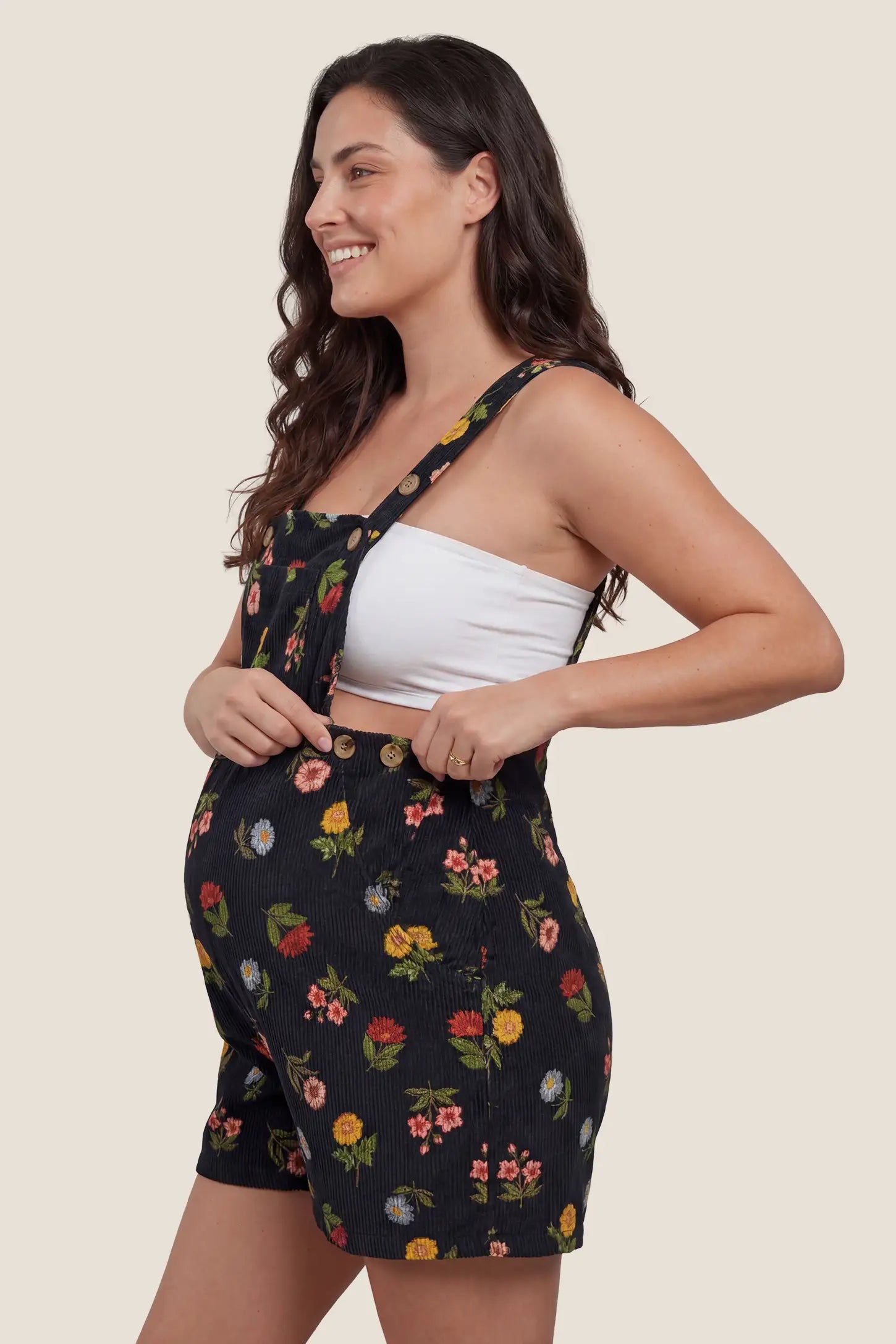 Adjustable Waist Front Pocket Maternity Short Overalls Side view of the black floral Adjustable Waist Front Pocket Maternity Short Overalls designed to fit comfortably throughout pregnancy.
