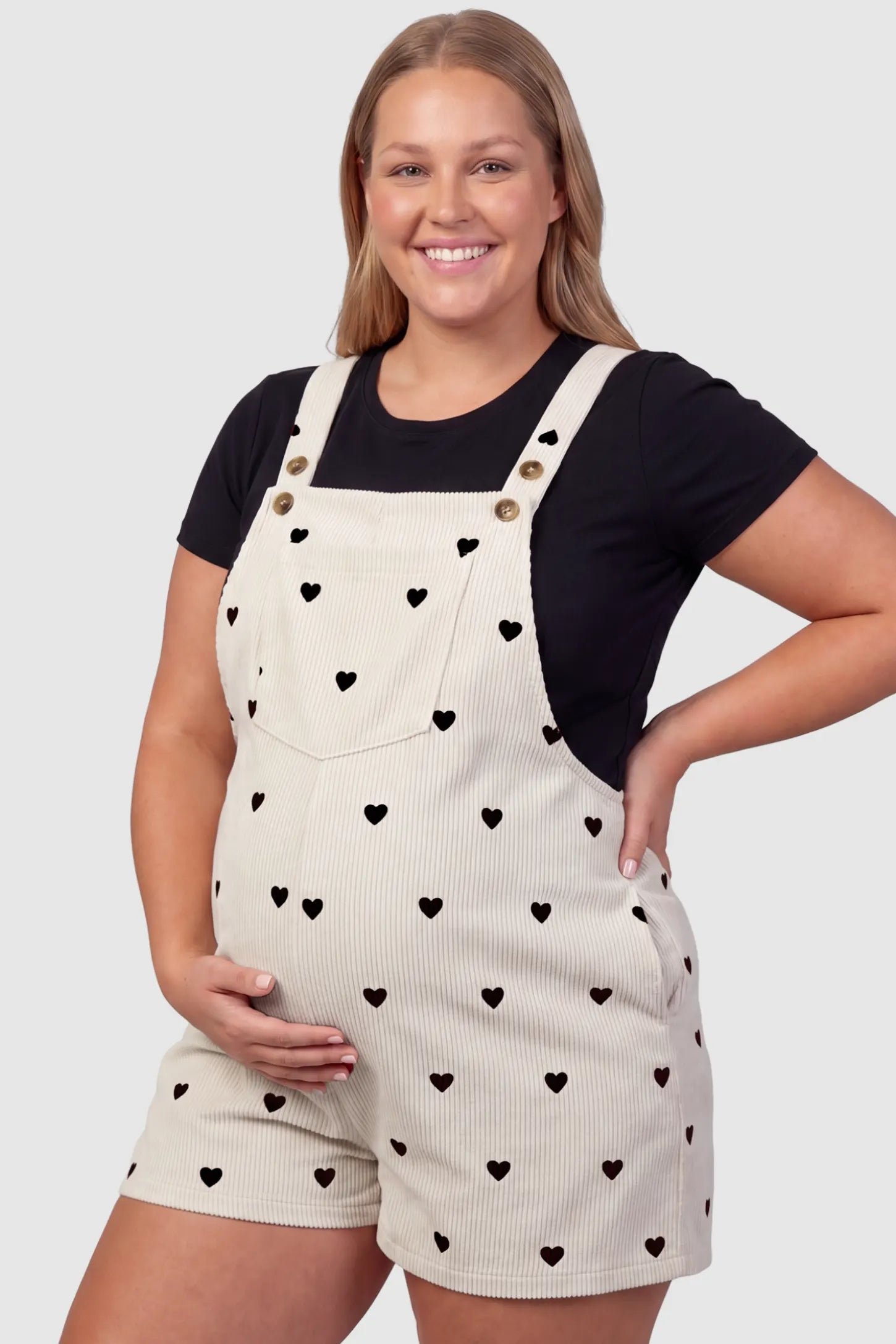 Adjustable Waist Front Pocket Maternity Short Overalls Adjustable Waist Front Pocket Maternity Short Overalls in black featuring an adjustable waist and front bib pocket on a plus size pregnant model, front view.