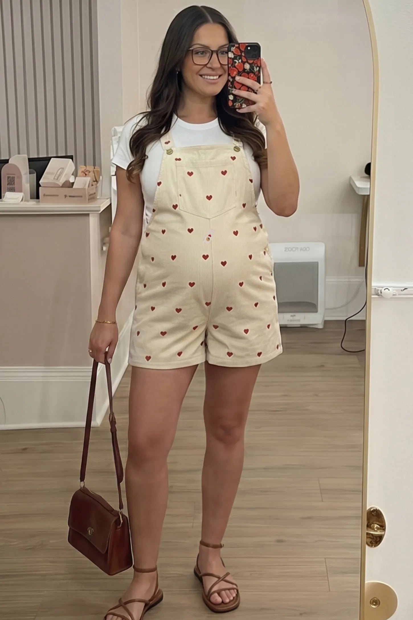 Adjustable Waist Front Pocket Maternity Short Overalls Adjustable Waist Front Pocket Maternity Short Overalls in red featuring an adjustable waist and front bib pocket on a pregnant woman in indoor setting, front view.