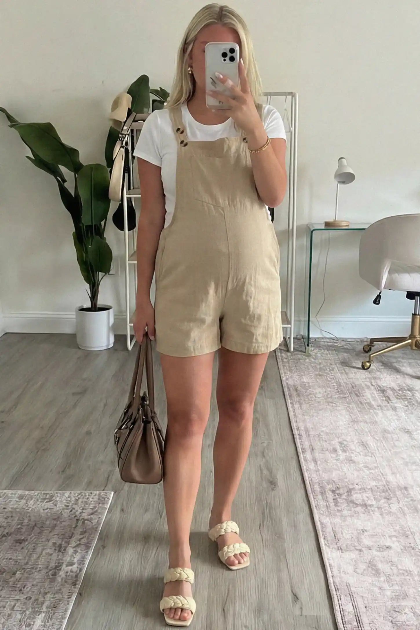 Adjustable Waist Pocketed Maternity Short Overalls Adjustable Waist Pocketed Maternity Short Overalls in Beige featuring a bib pocket on a pregnant woman in indoor setting, front view.