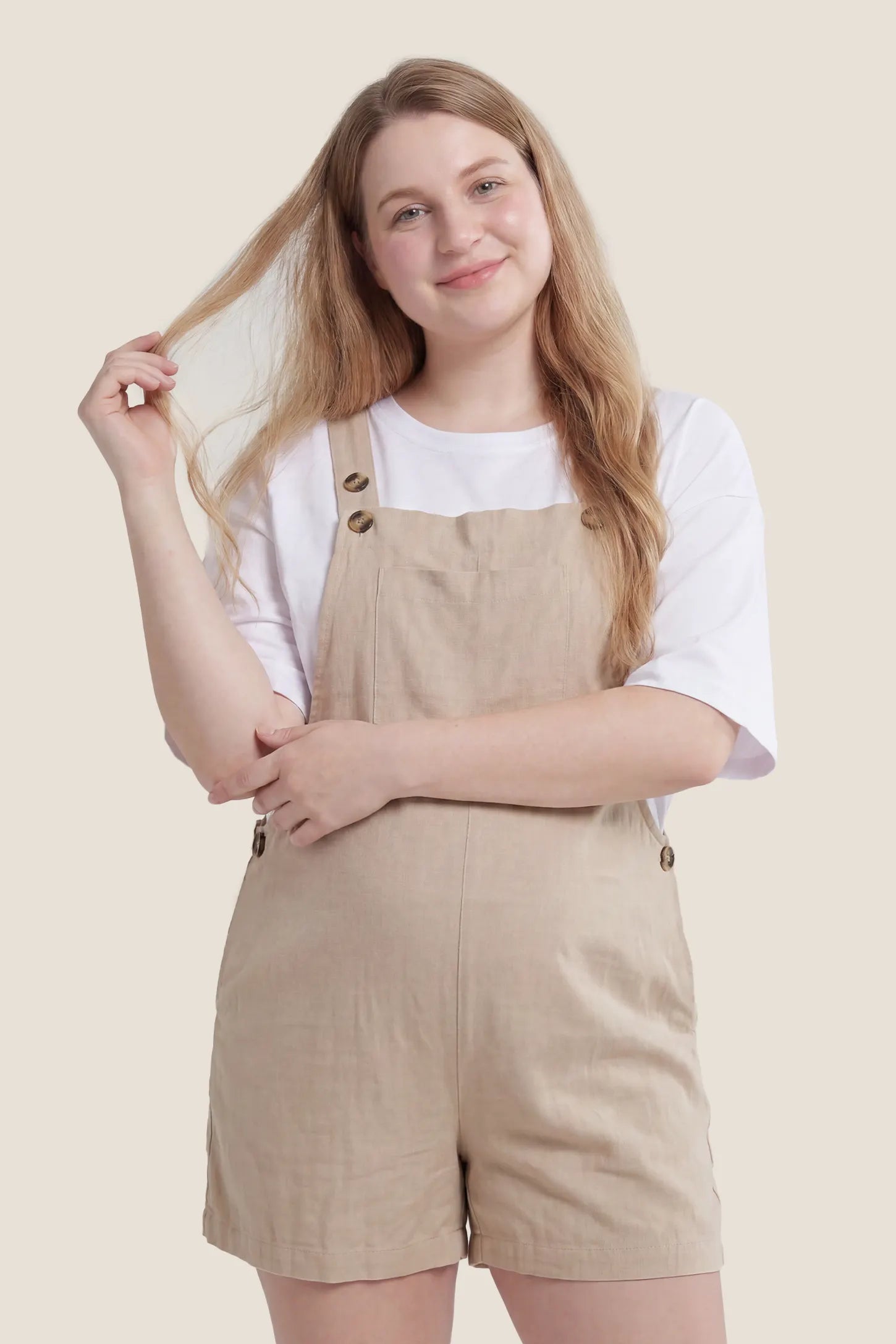 Adjustable Waist Pocketed Maternity Short Overalls Front view of the beige Adjustable Waist Pocketed Maternity Short Overalls with pockets and an adjustable waist design.