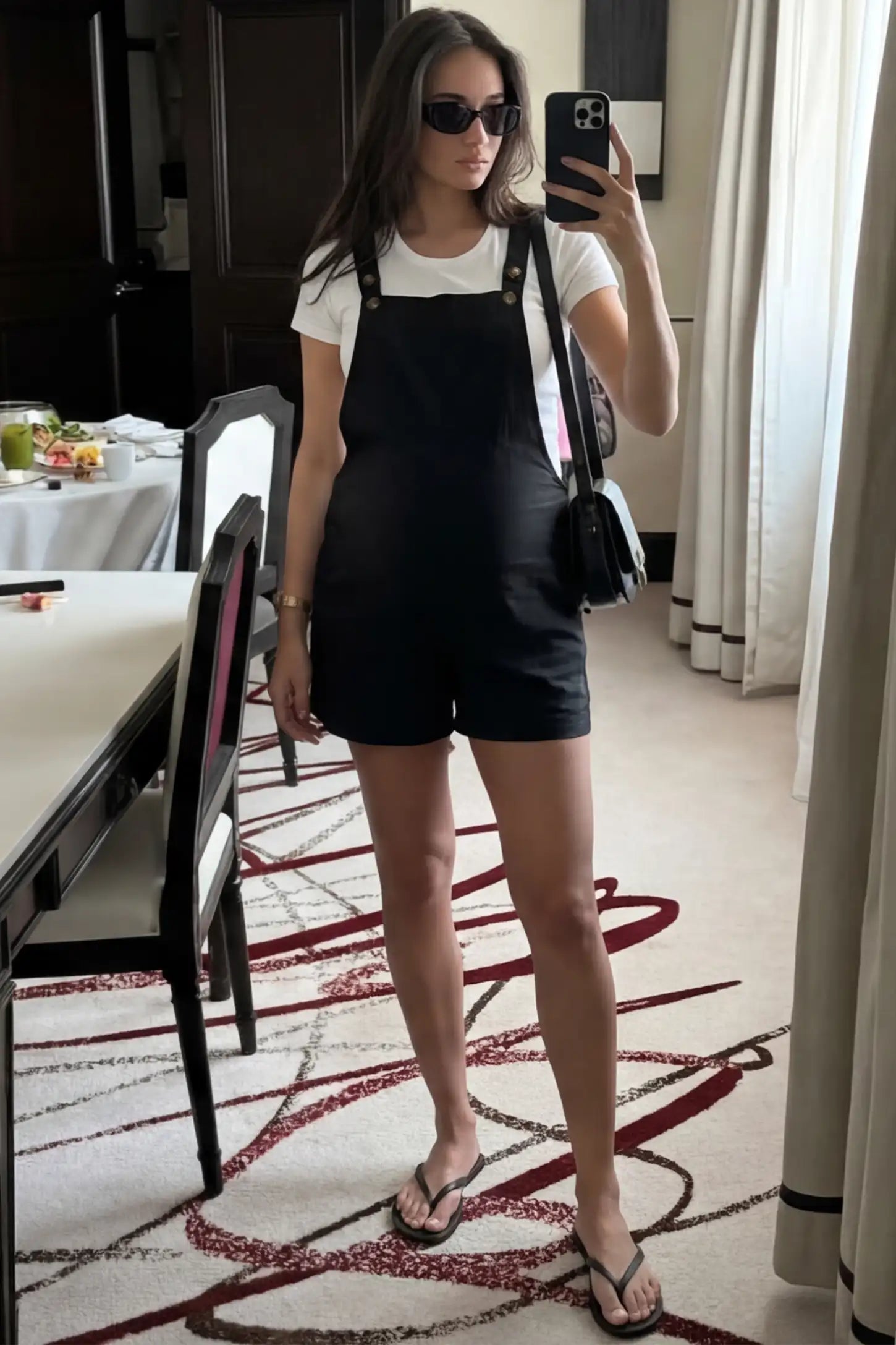 Adjustable Waist Pocketed Maternity Short Overalls Adjustable Waist Pocketed Maternity Short Overalls in Black featuring a bib pocket on a pregnant woman in indoor setting, front view.