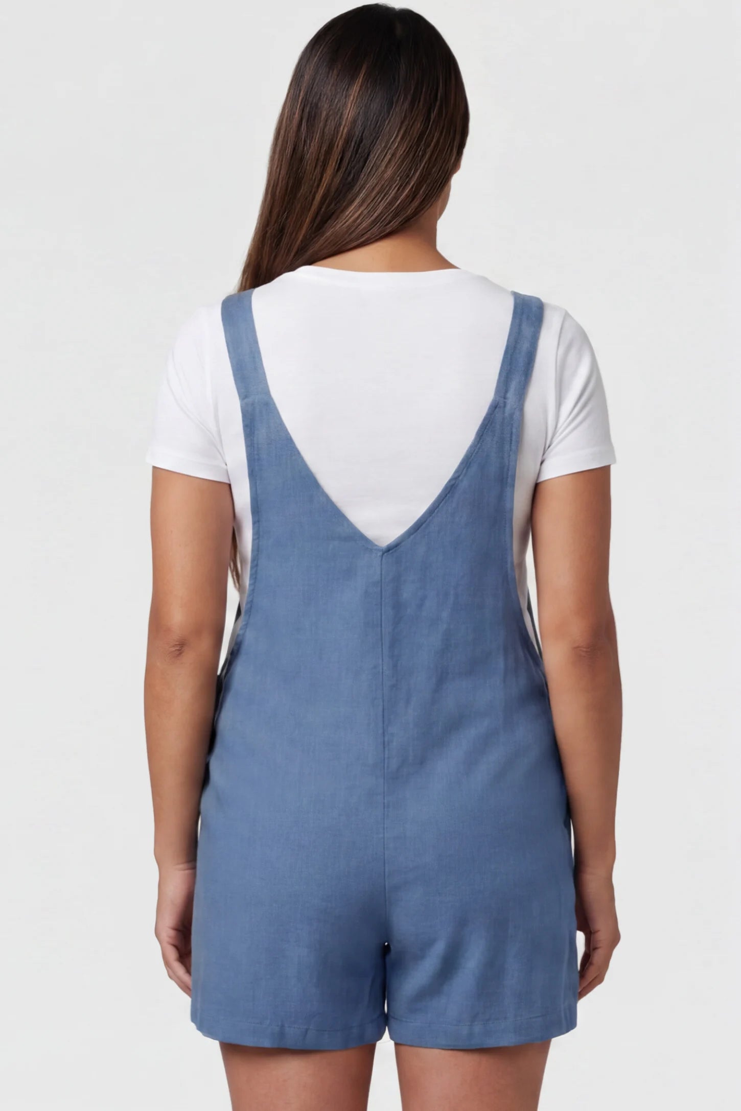 Adjustable Waist Pocketed Maternity Short Overalls Adjustable Waist Pocketed Maternity Short Overalls in Blue featuring a V-shaped back and wide straps on a model, back view.