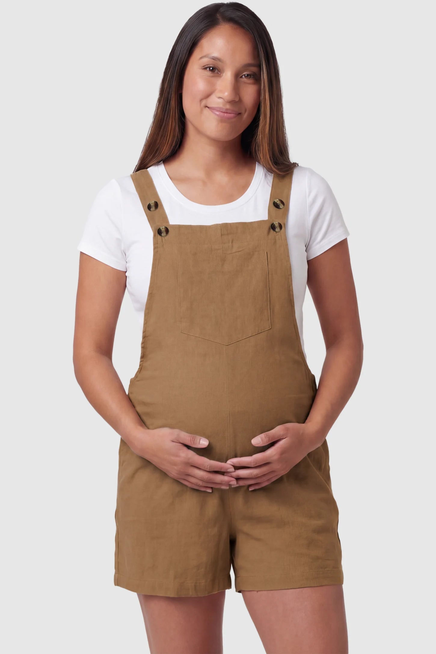 Adjustable Waist Pocketed Maternity Short Overalls Adjustable Waist Pocketed Maternity Short Overalls in Brown featuring a bib pocket on a pregnant model, front view.