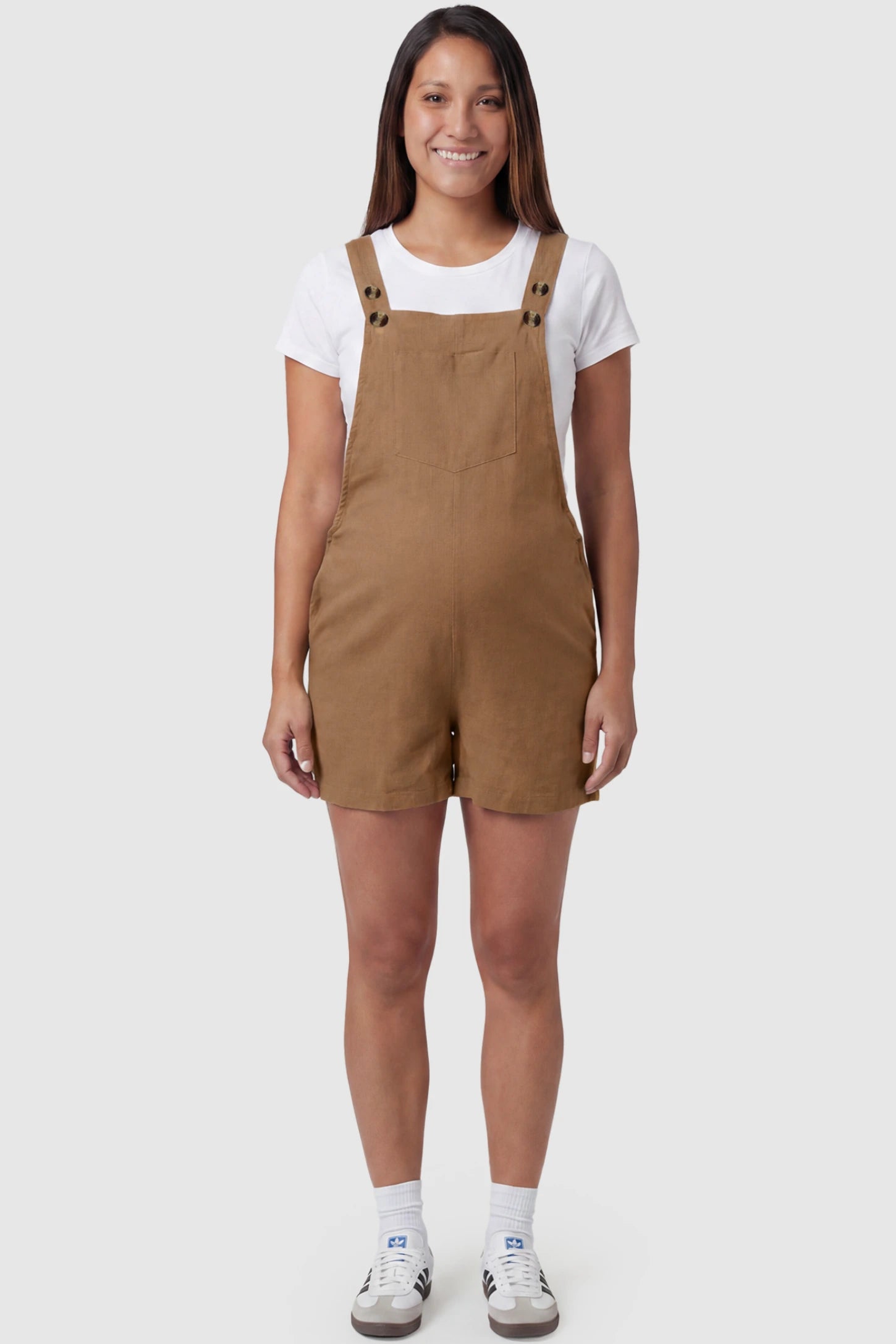 Adjustable Waist Pocketed Maternity Short Overalls Adjustable Waist Pocketed Maternity Short Overalls in Brown featuring a bib pocket on a pregnant model, full body view.