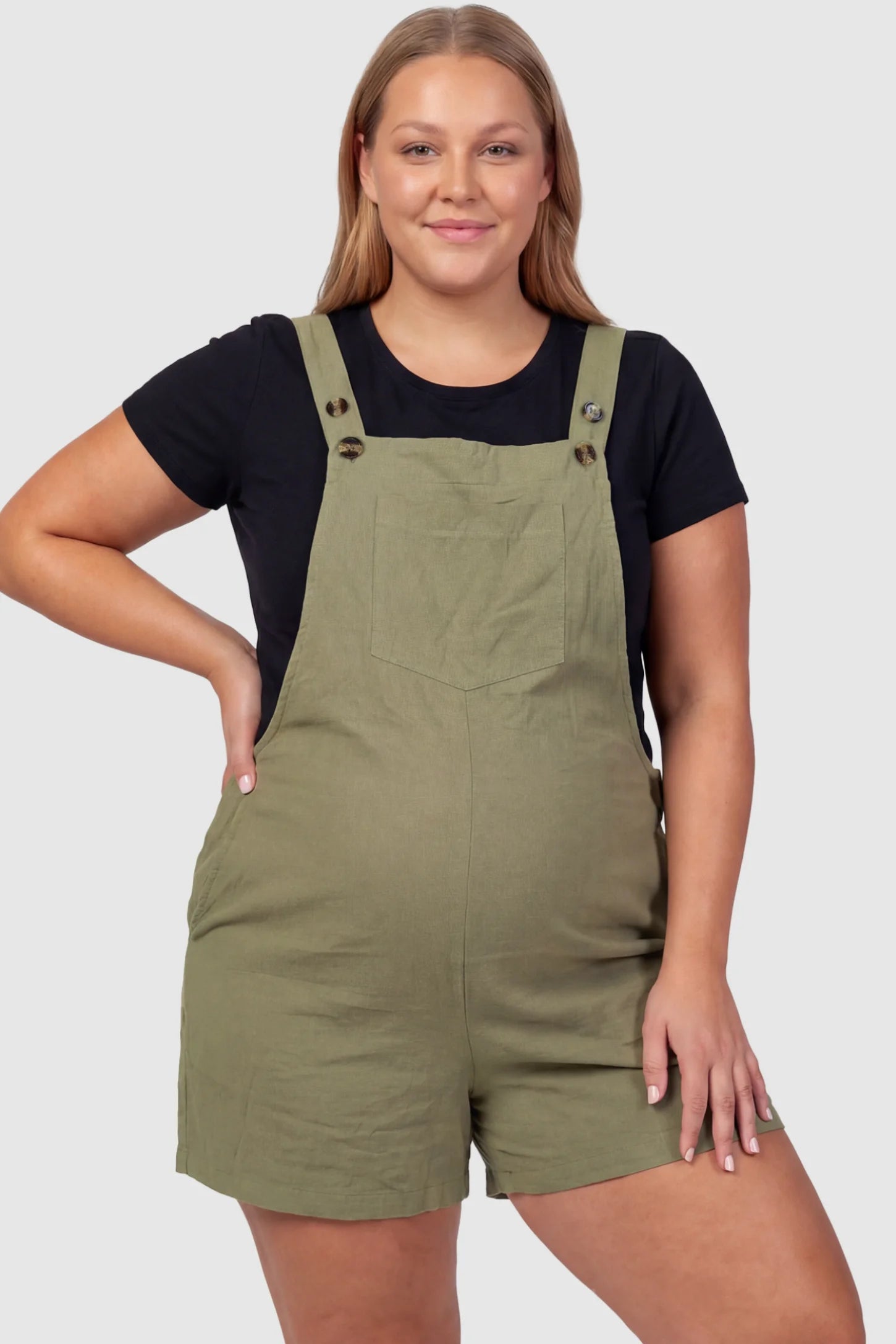 Adjustable Waist Pocketed Maternity Short Overalls Adjustable Waist Pocketed Maternity Short Overalls in Green featuring a bib pocket on a plus size pregnant model, front view.