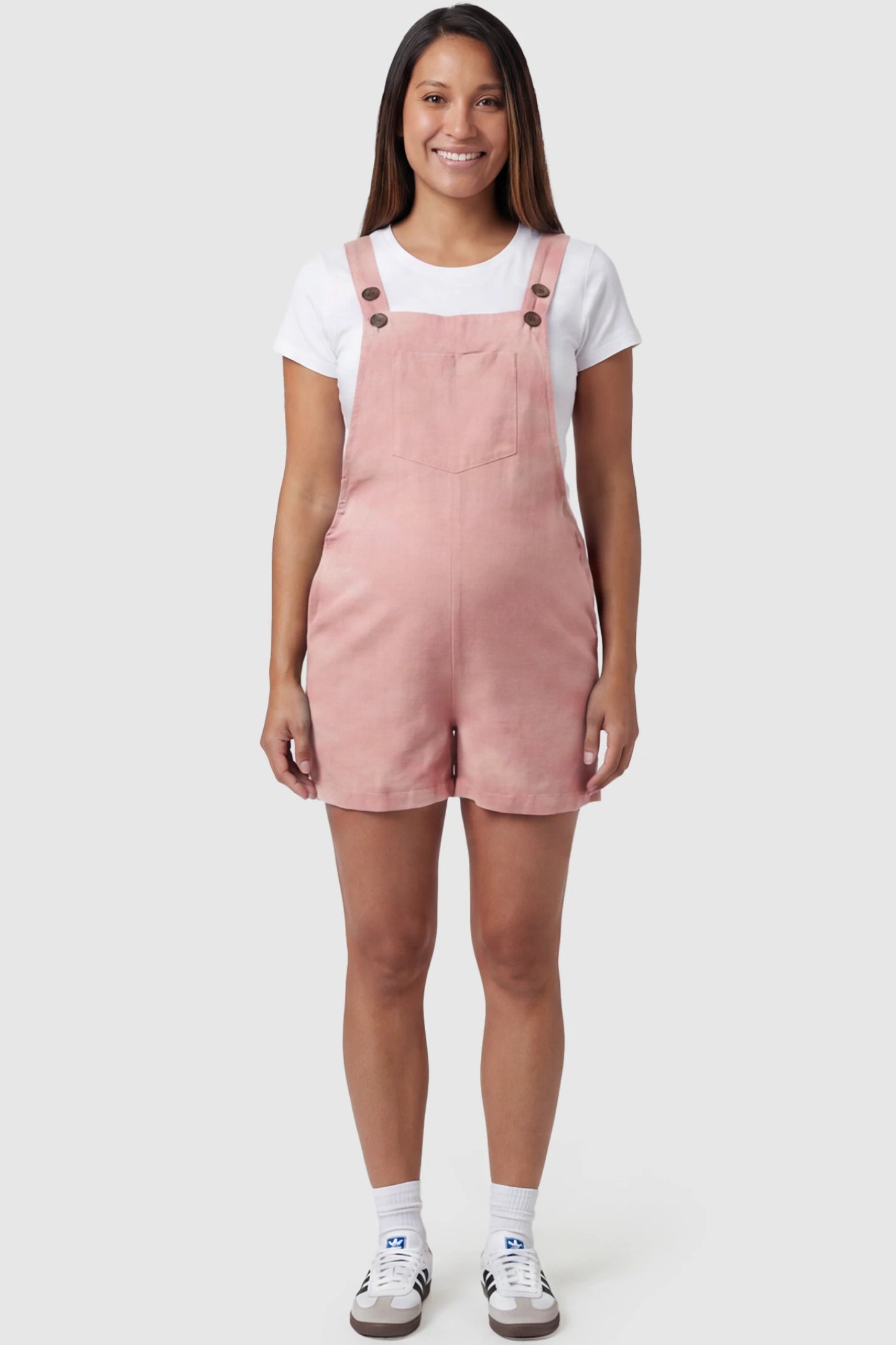 Adjustable Waist Pocketed Maternity Short Overalls Adjustable Waist Pocketed Maternity Short Overalls in Pink featuring a bib pocket on a pregnant model, full body view.