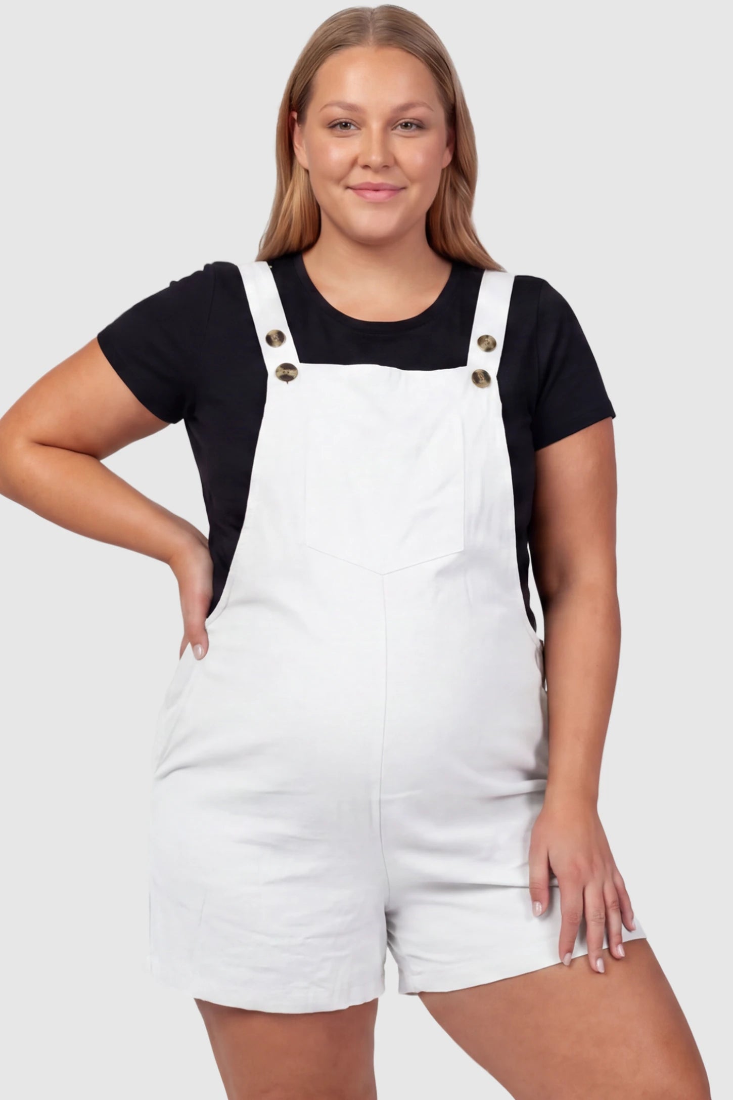 Adjustable Waist Pocketed Maternity Short Overalls Adjustable Waist Pocketed Maternity Short Overalls in White featuring a bib pocket on a plus size pregnant model, front view.