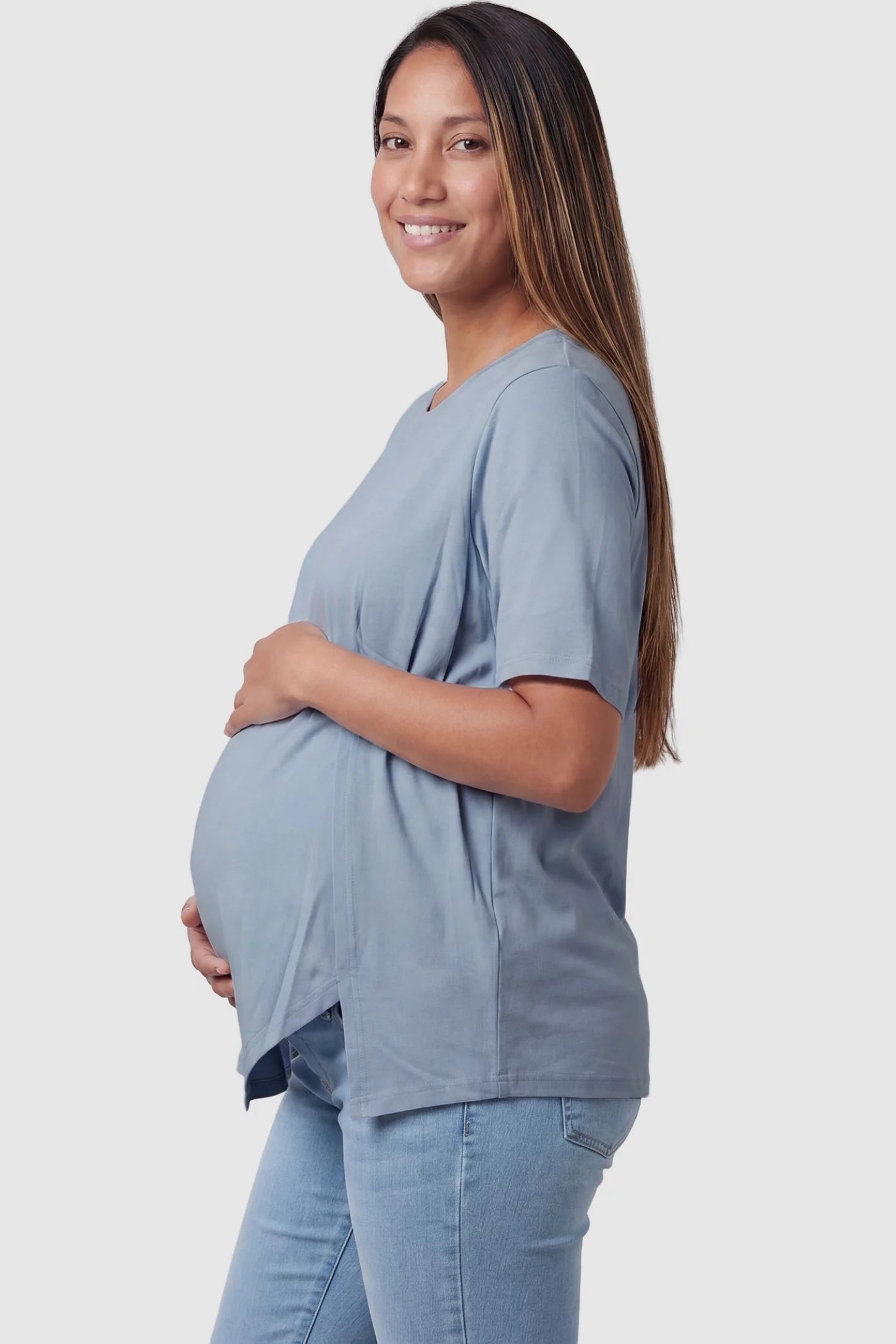 Side view of Asymmetrical Hem Relaxed Short Sleeve Maternity Top in Blue featuring a side-slit hem on a pregnant model.