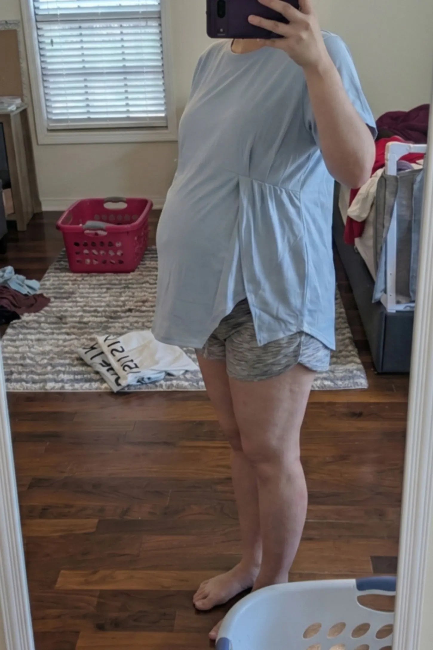 Asymmetrical Hem Relaxed Short Sleeve Maternity Top Side view of Asymmetrical Hem Relaxed Short Sleeve Maternity Top in Blue featuring a flexible side slit on a pregnant model.