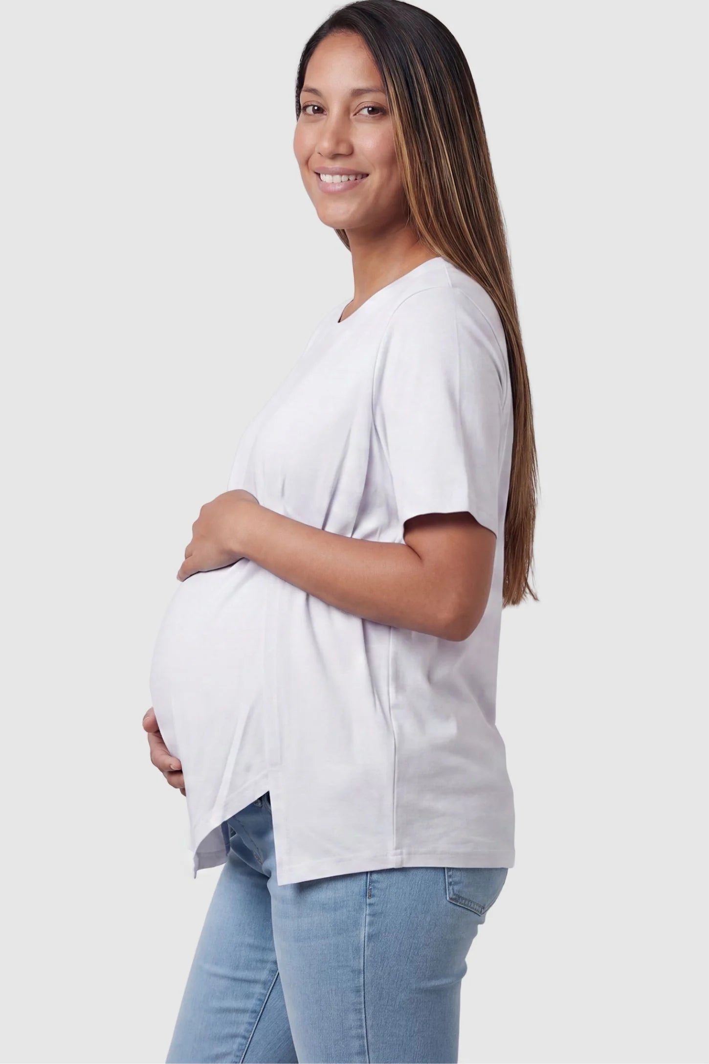 Asymmetrical Hem Relaxed Short Sleeve Maternity Top Side view of Asymmetrical Hem Relaxed Short Sleeve Maternity Top in White featuring a side-slit hem on a pregnant model.