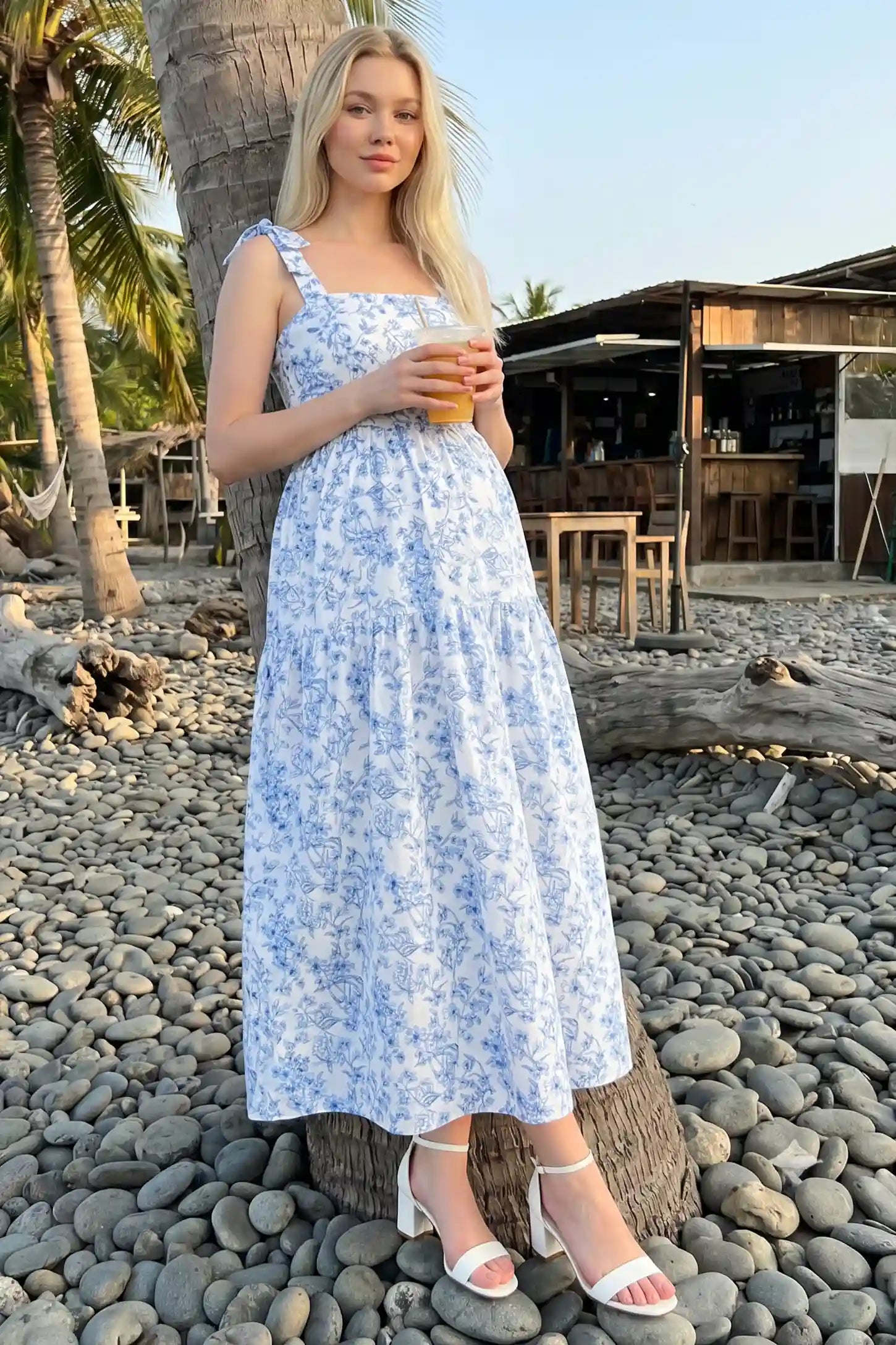 Floral Cami Tiered Maxi Maternity Dress Blue and white floral cami maternity tiered maxi dress on a pregnant model, showcasing the light and airy fabric.