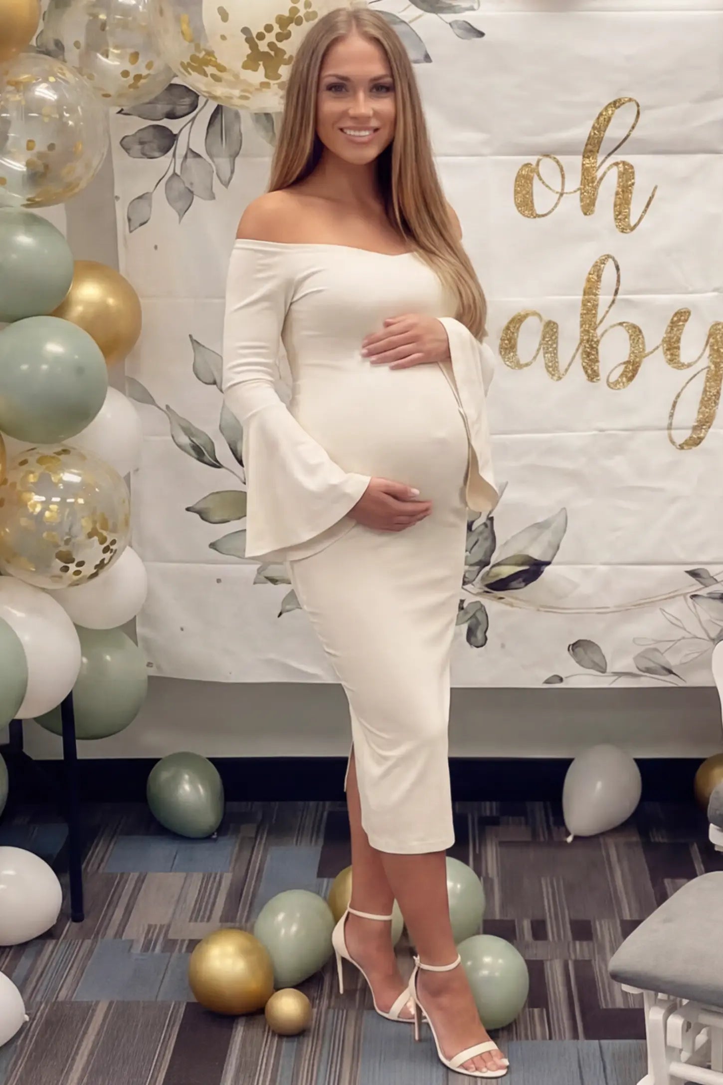 Boat Neck Bell Sleeve Maternity Midi Dress Boat Neck Bell Sleeve Maternity Midi Dress in beige featuring a high stretch fit on a pregnant woman at an outdoor event front view.