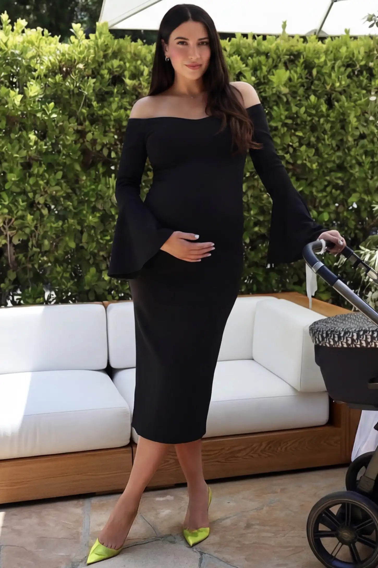 Boat Neck Bell Sleeve Maternity Midi Dress in Black featuring a high stretch fit on a pregnant woman at an outdoor event front view.