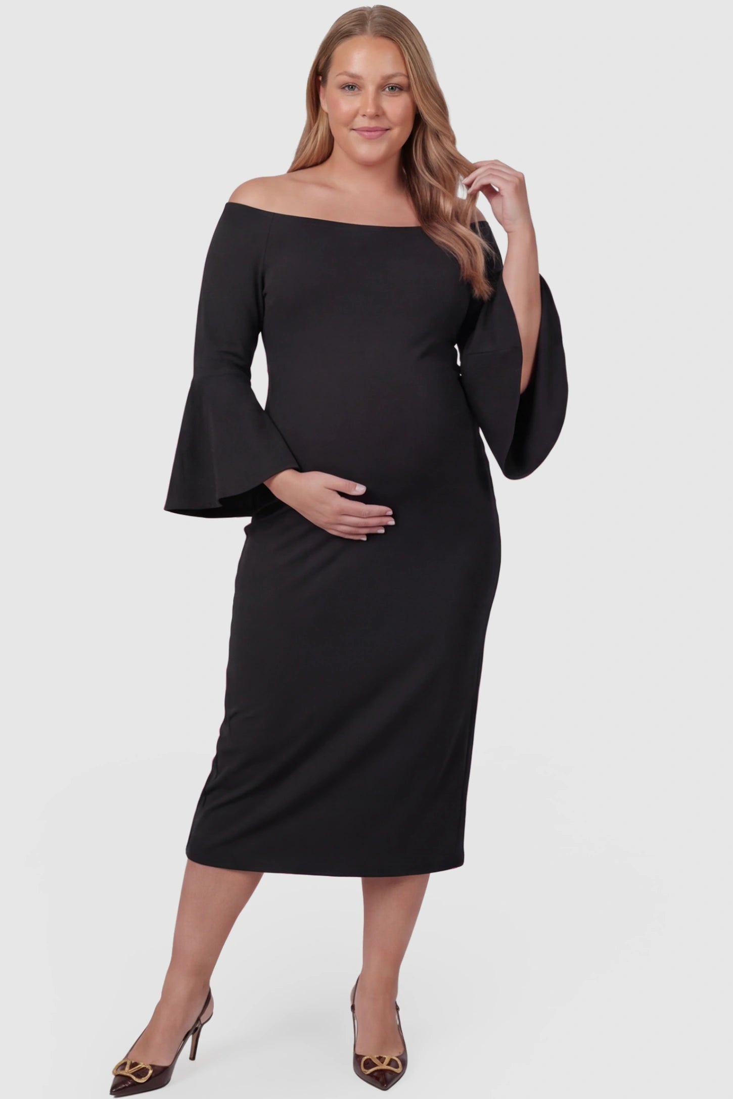 Boat Neck Bell Sleeve Maternity Midi Dress Boat Neck Bell Sleeve Maternity Midi Dress in Black featuring a high stretch fit on a plus size pregnant model front view.