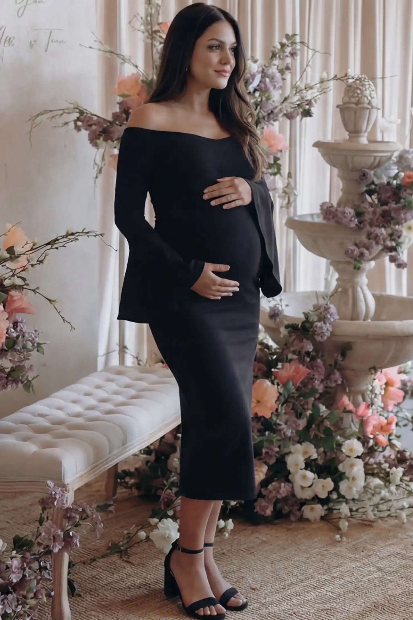 Boat Neck Bell Sleeve Maternity Midi Dress Boat Neck Bell Sleeve Maternity Midi Dress in Black featuring a high stretch fit on a pregnant woman at an outdoor event side view.