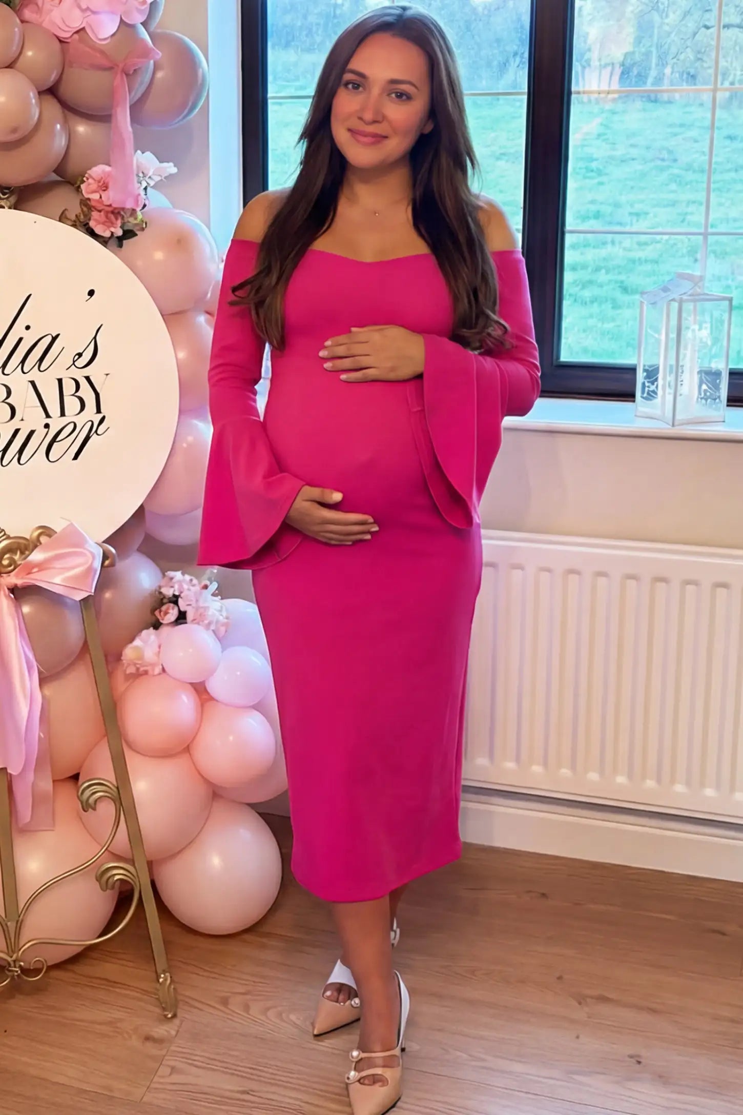 Boat Neck Bell Sleeve Maternity Midi Dress Boat Neck Bell Sleeve Maternity Midi Dress in magenta featuring a high stretch fit on a pregnant woman at an outdoor event front view.