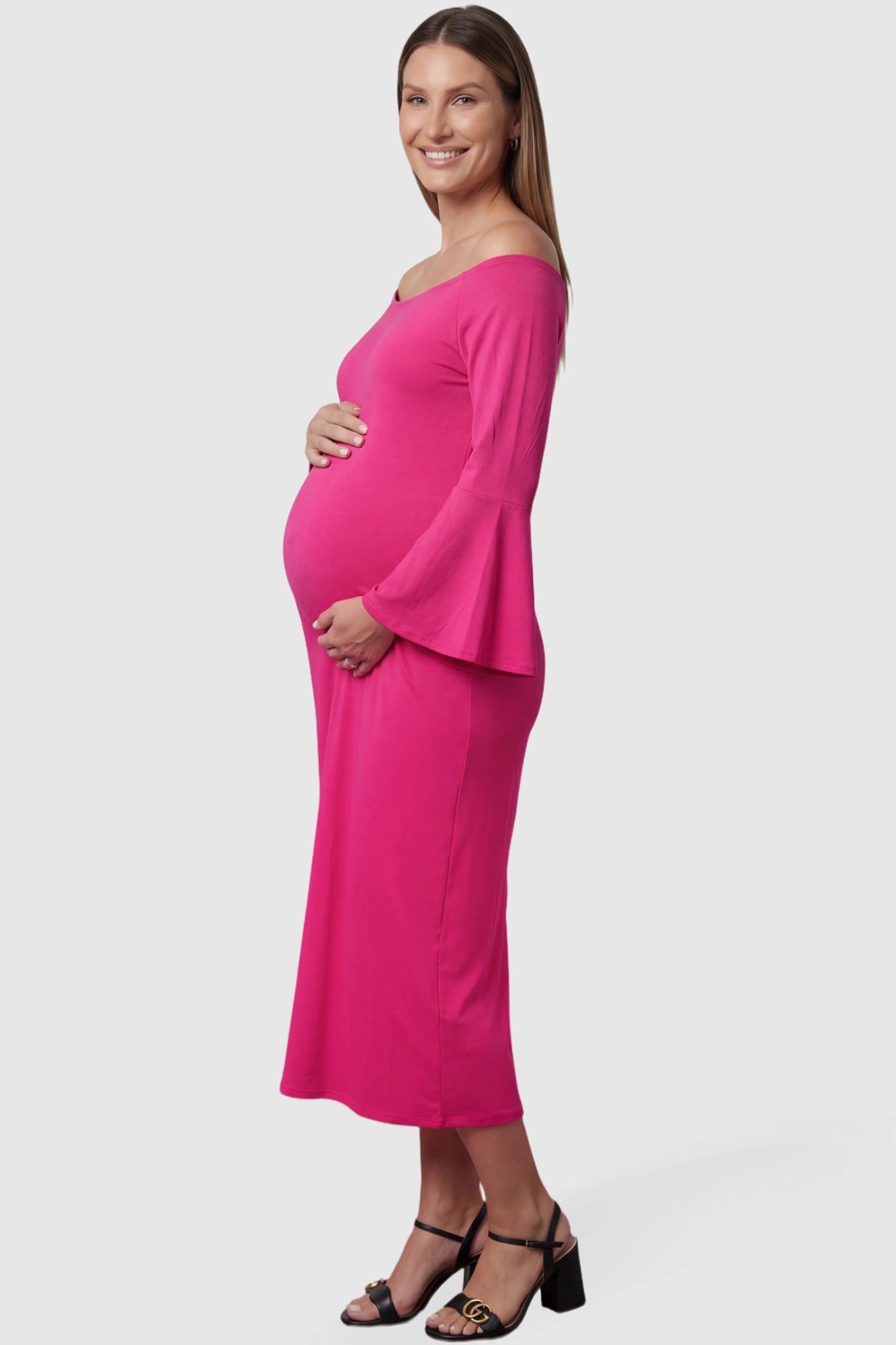 Boat Neck Bell Sleeve Maternity Midi Dress Boat Neck Bell Sleeve Maternity Midi Dress in magenta featuring a high stretch fit on a pregnant model side view.