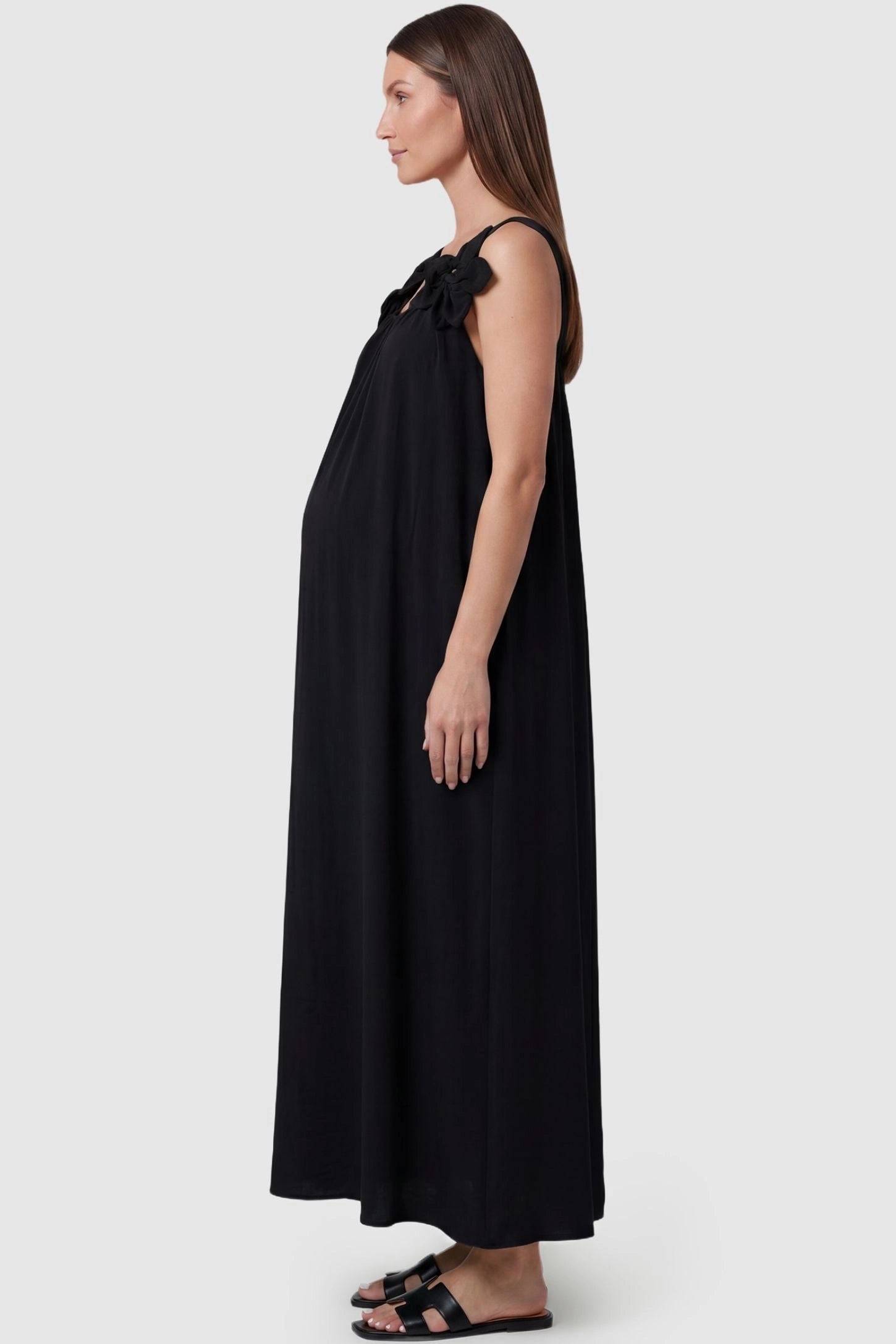 Bow Strap A-Line Maternity Dress Side view of Black Bow Strap A-Line Maternity Dress featuring a flowy silhouette on a pregnant model.