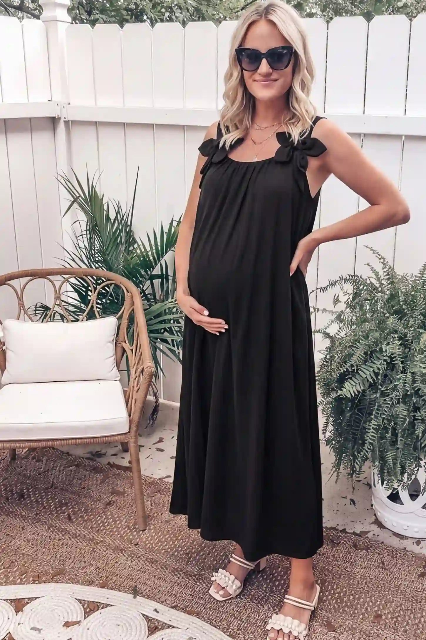 Bow Strap A-Line Maternity Dress Elegant Black Bow Strap A-Line Maternity Dress on a model posed in a rustic courtyard setting.
