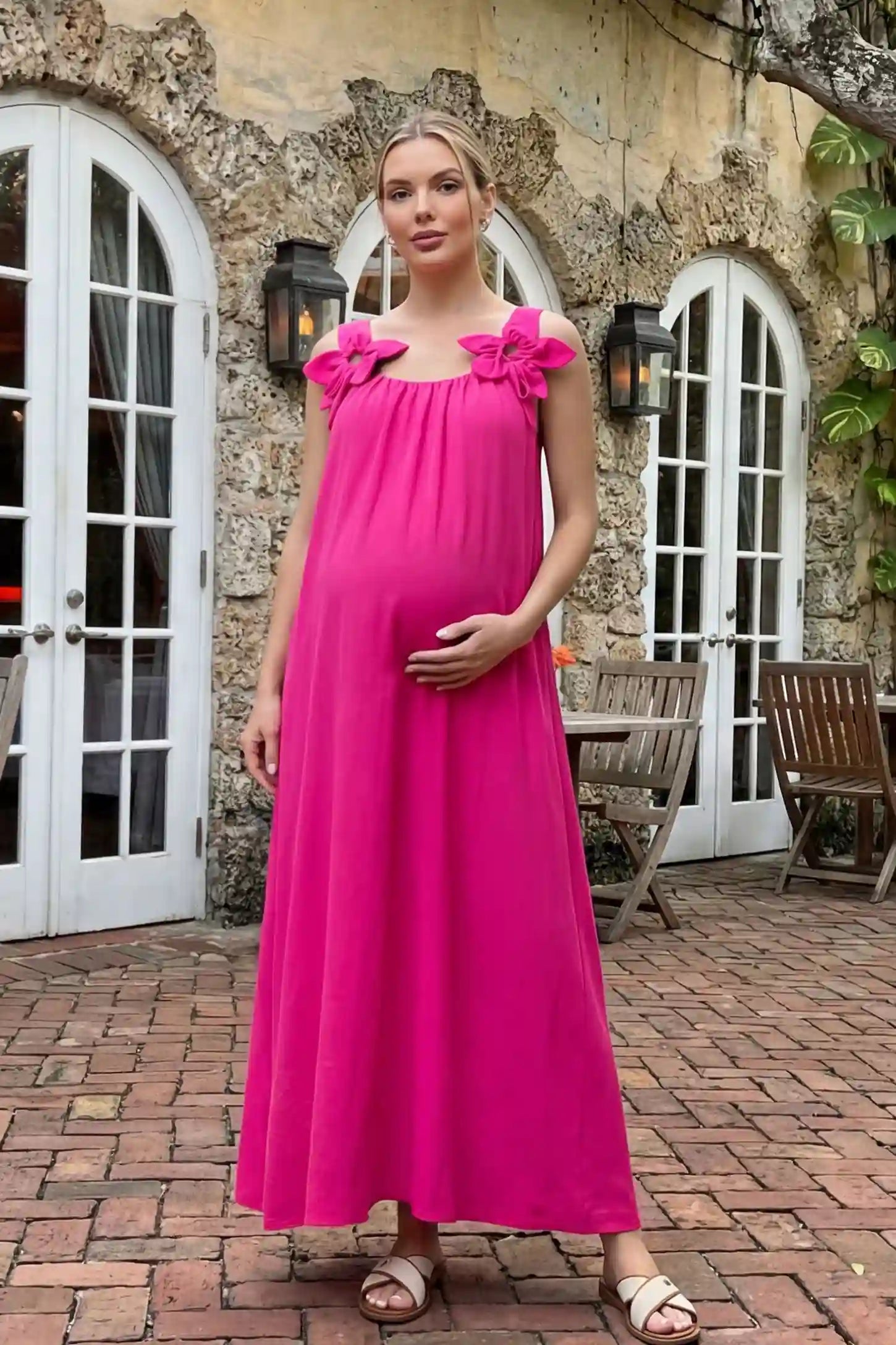 Bow Strap A-Line Maternity Dress Vibrant Pink Bow Strap A-Line Maternity Dress on a model posed in a scenic Mediterranean courtyard.